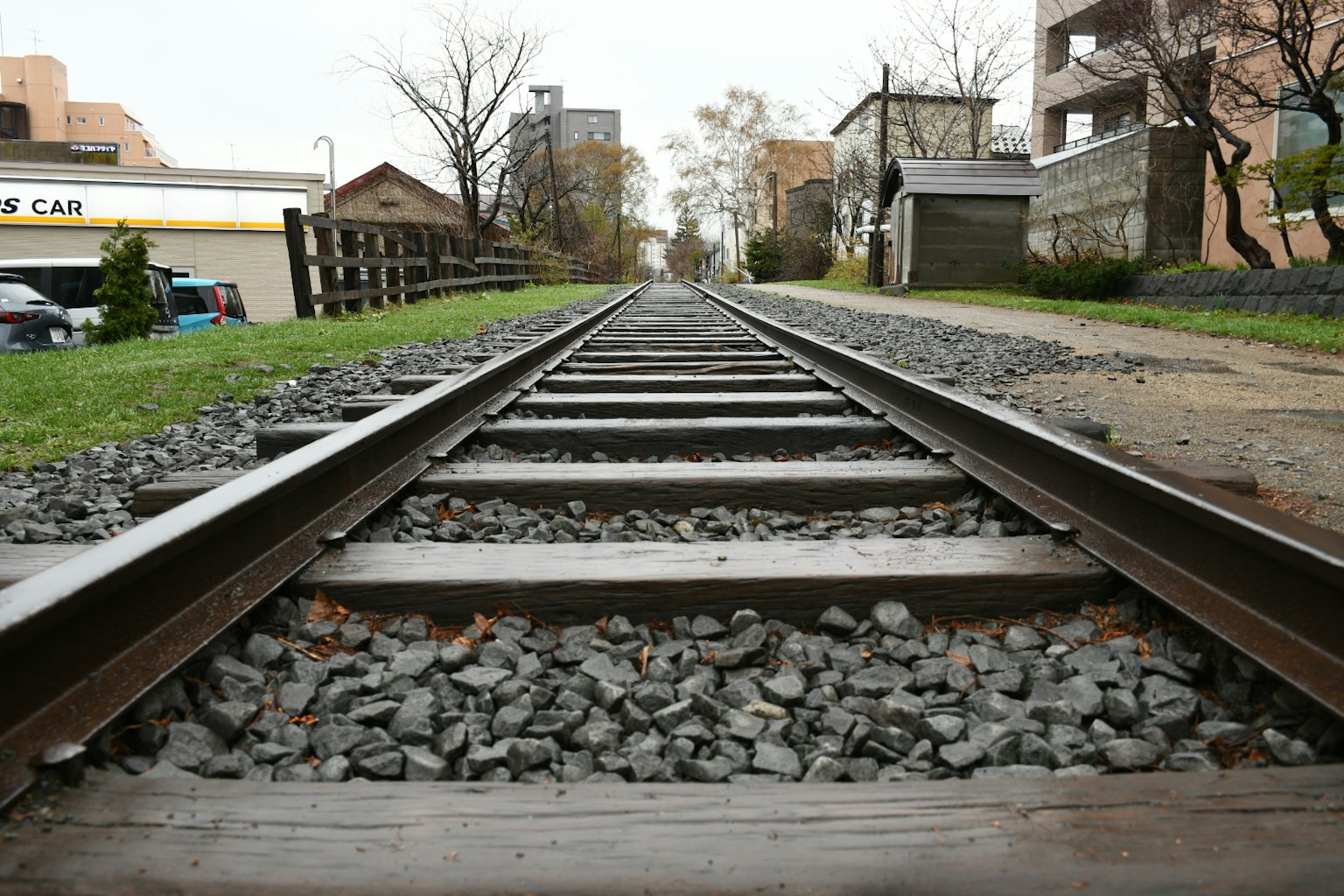 Vue en contre-plongée des rails avec des arbres et des bâtiments environnants