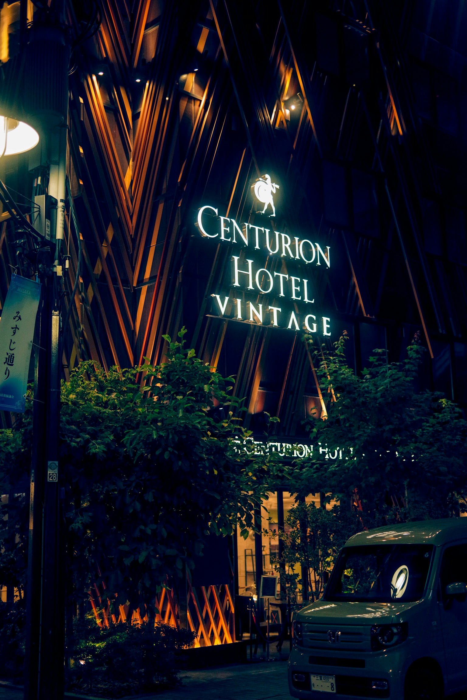 Extérieur de l'Hôtel Centurion Vintage la nuit avec enseigne illuminée et verdure
