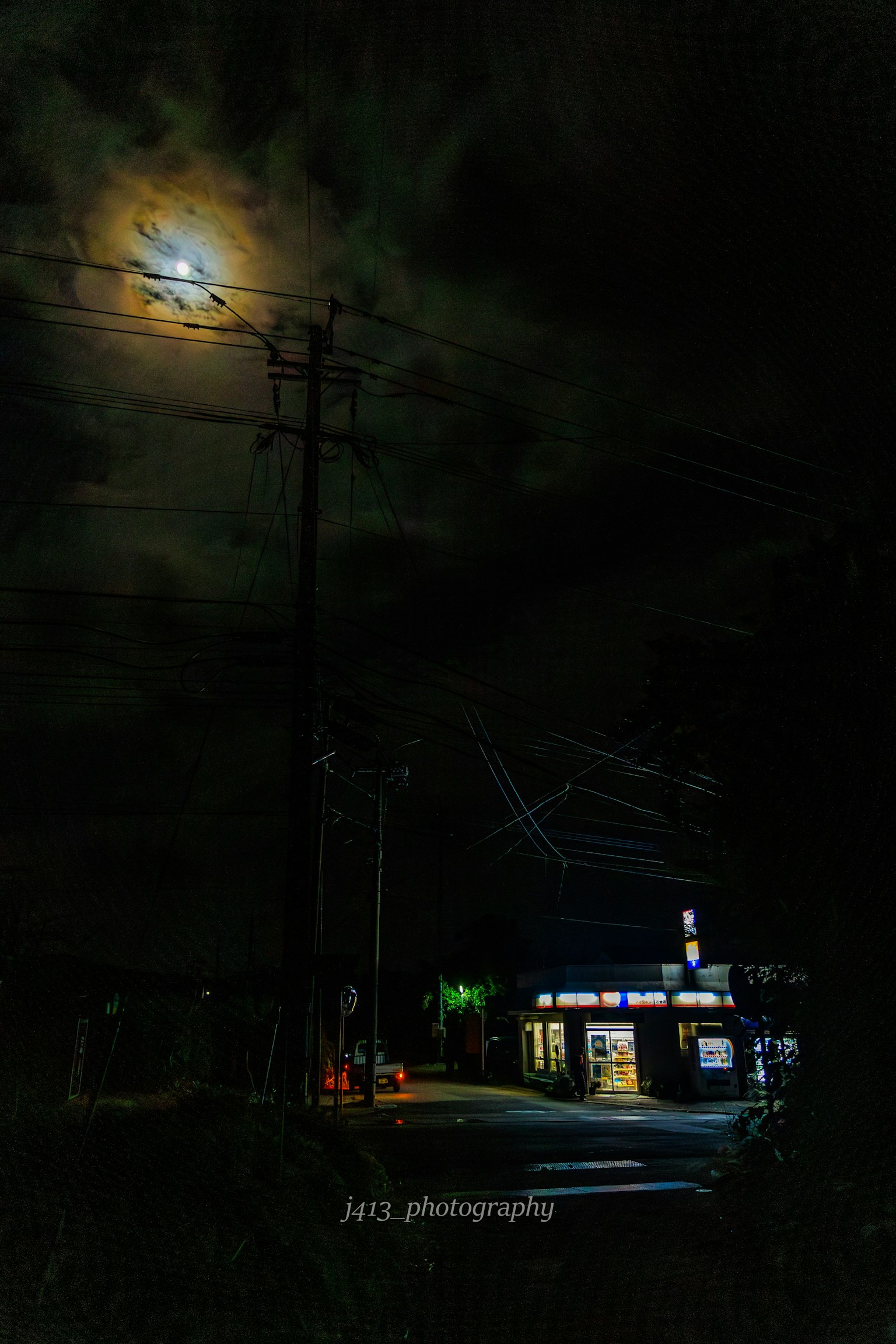 Pemandangan malam dengan bulan terang dan langit gelap di atas toko