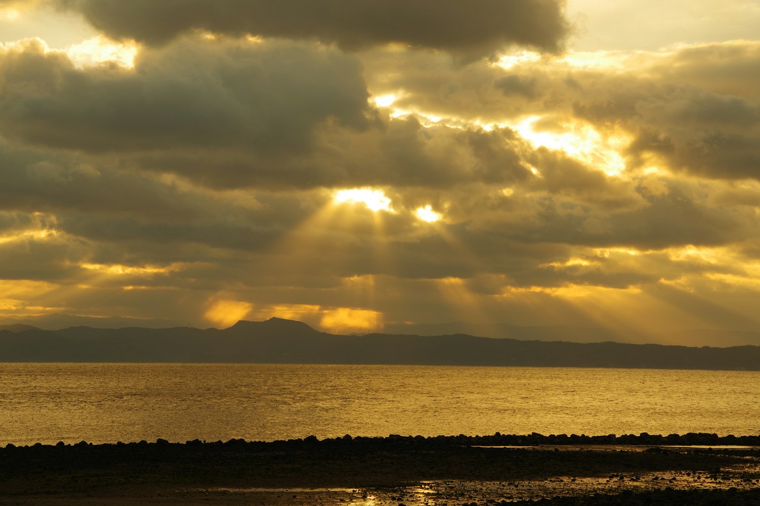 Beautiful sunset over the ocean with rays of light breaking through clouds