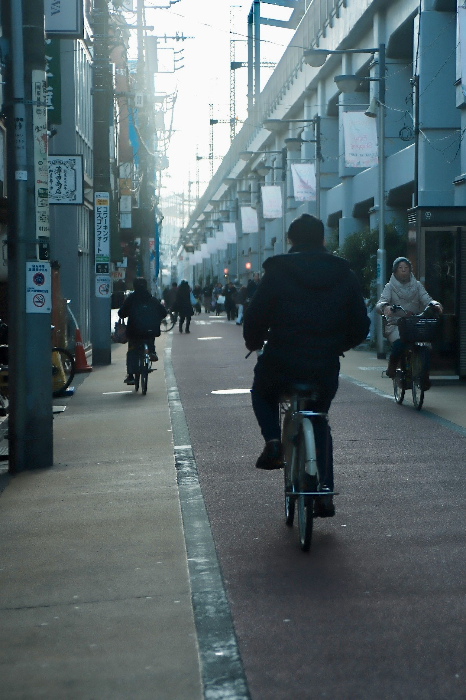自転車が走る狭い路地の商店街の通り