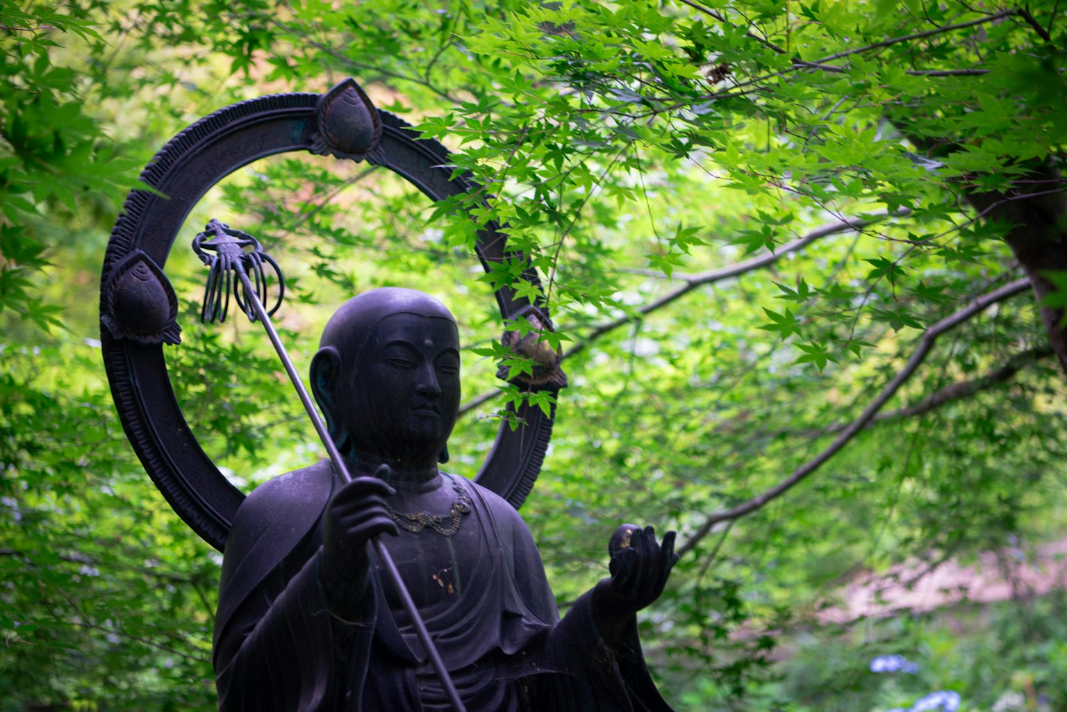 A serene statue surrounded by lush green trees