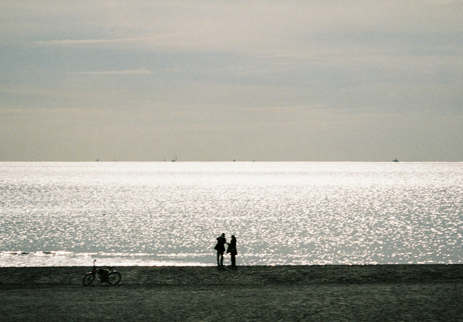 Pareja en una playa tranquila mirando al mar