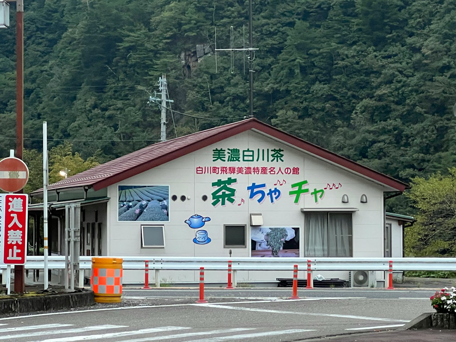 白川茶店外观，背景为绿色山脉