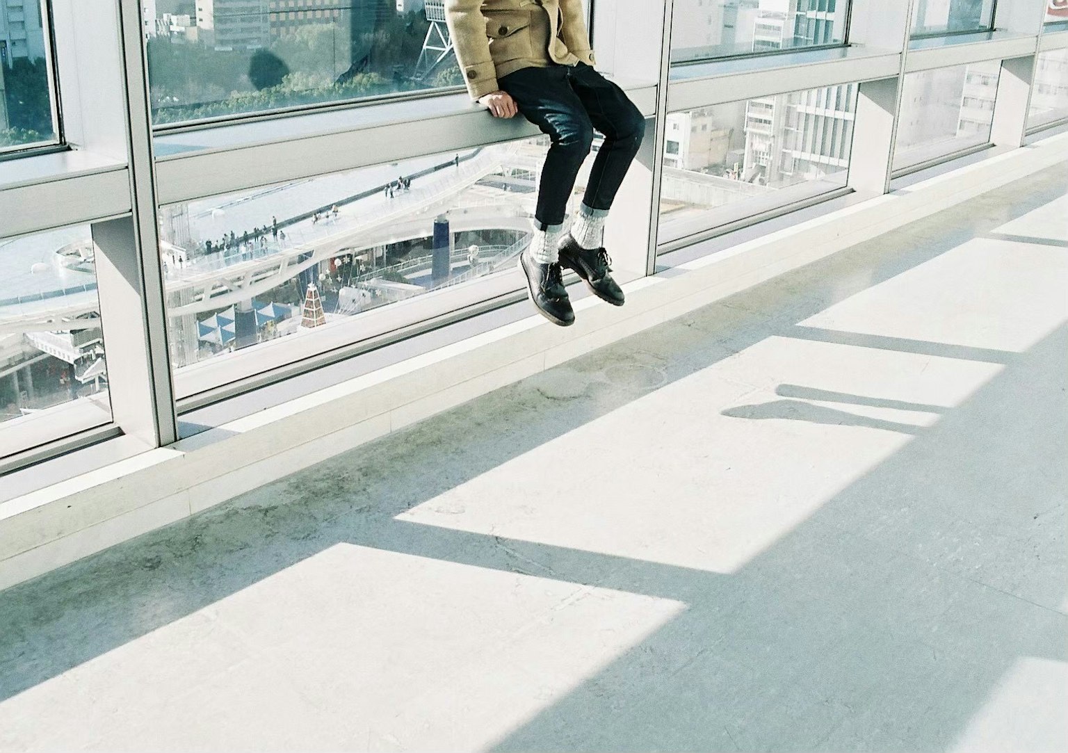 창가에 앉아 발이 공중에 떠 있는 모습