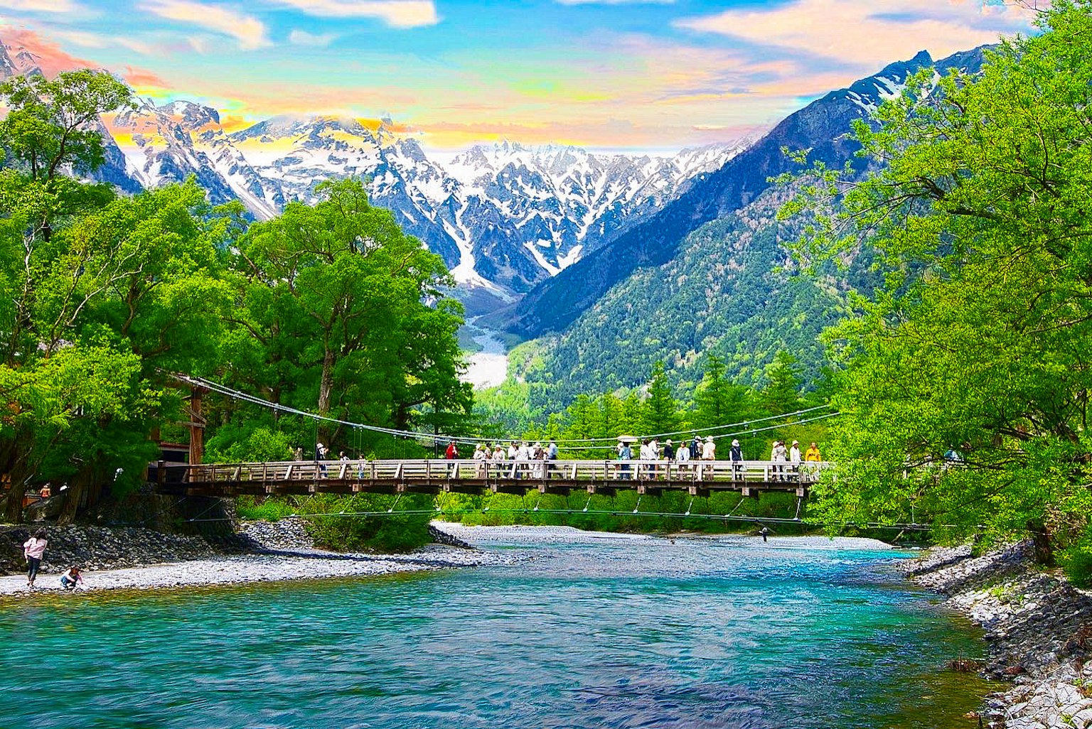 Scenic river view with a suspension bridge surrounded by mountains
