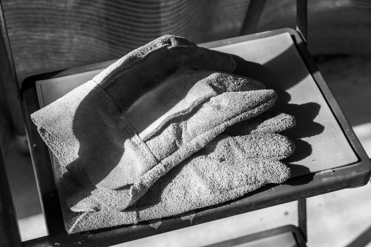 Guantes en blanco y negro descansando sobre una silla