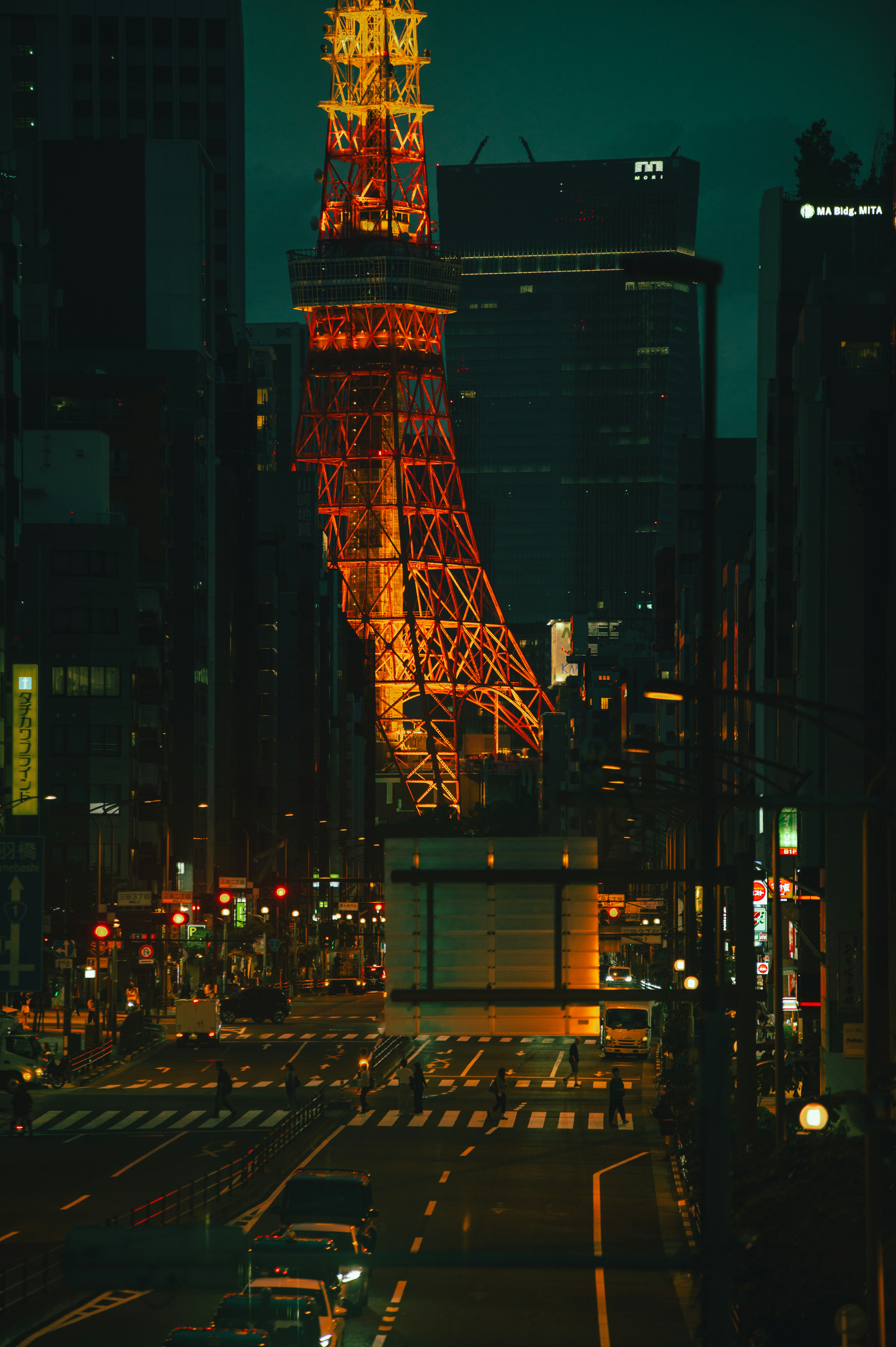 夜の高層ビル街にそびえるタワークレーンのある交差点