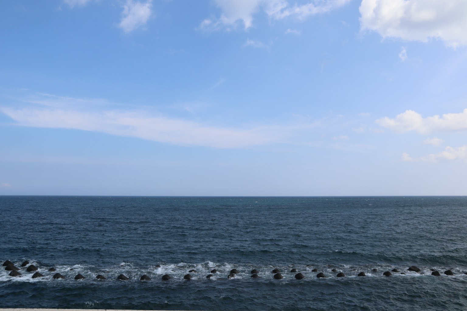 Weites blaues Meer unter einem klaren Himmel mit sanften Wellen
