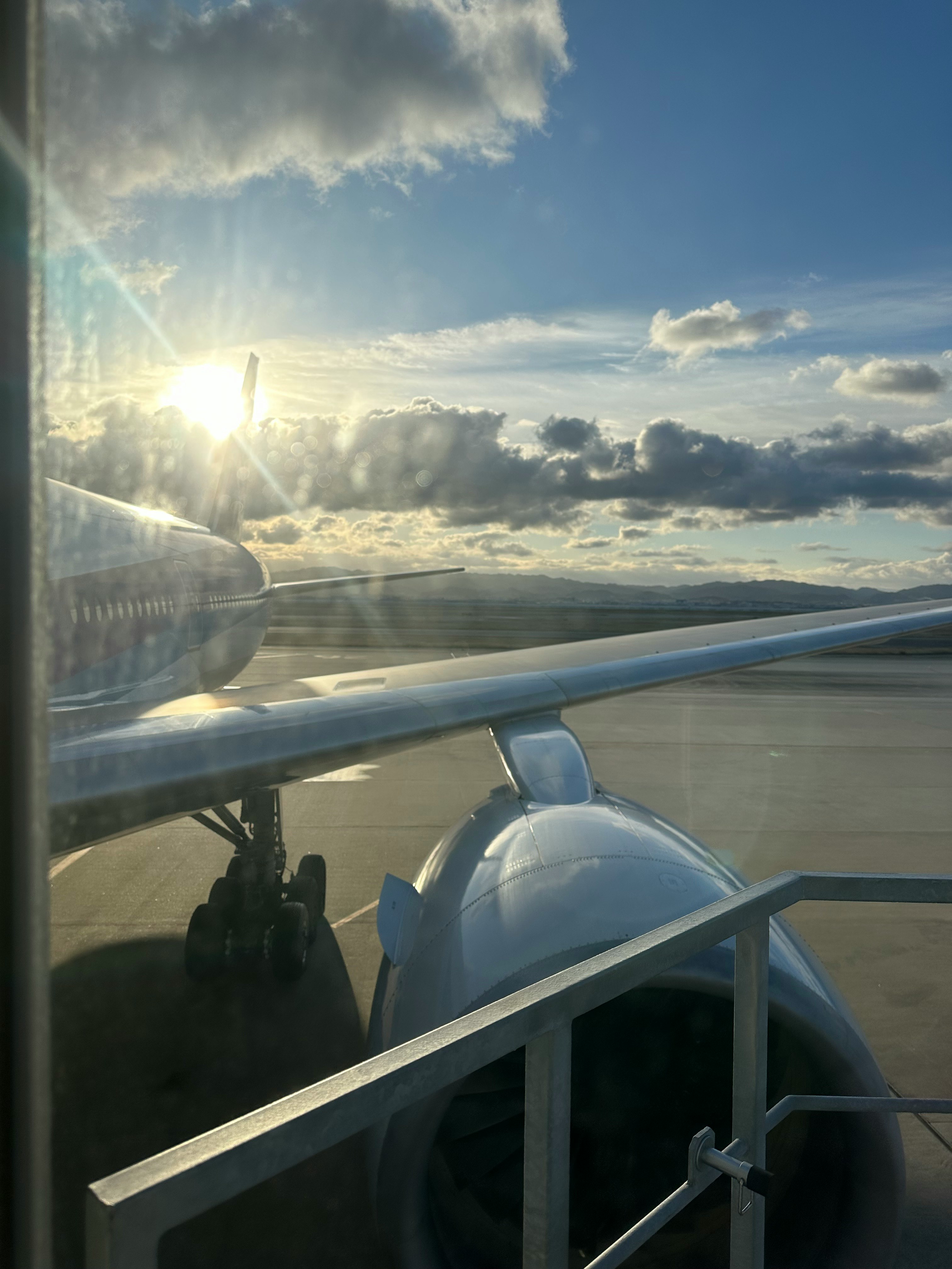 飛行機の窓から見える朝日と雲の空