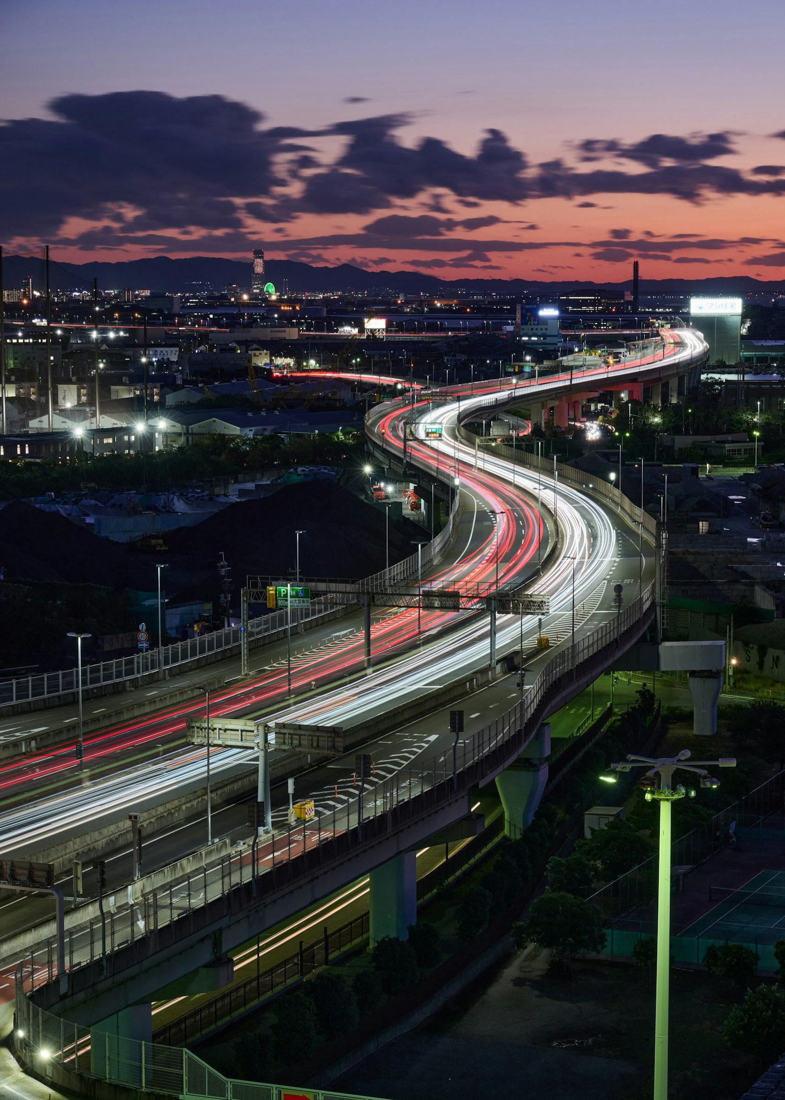 Curving road with light trails at dusk