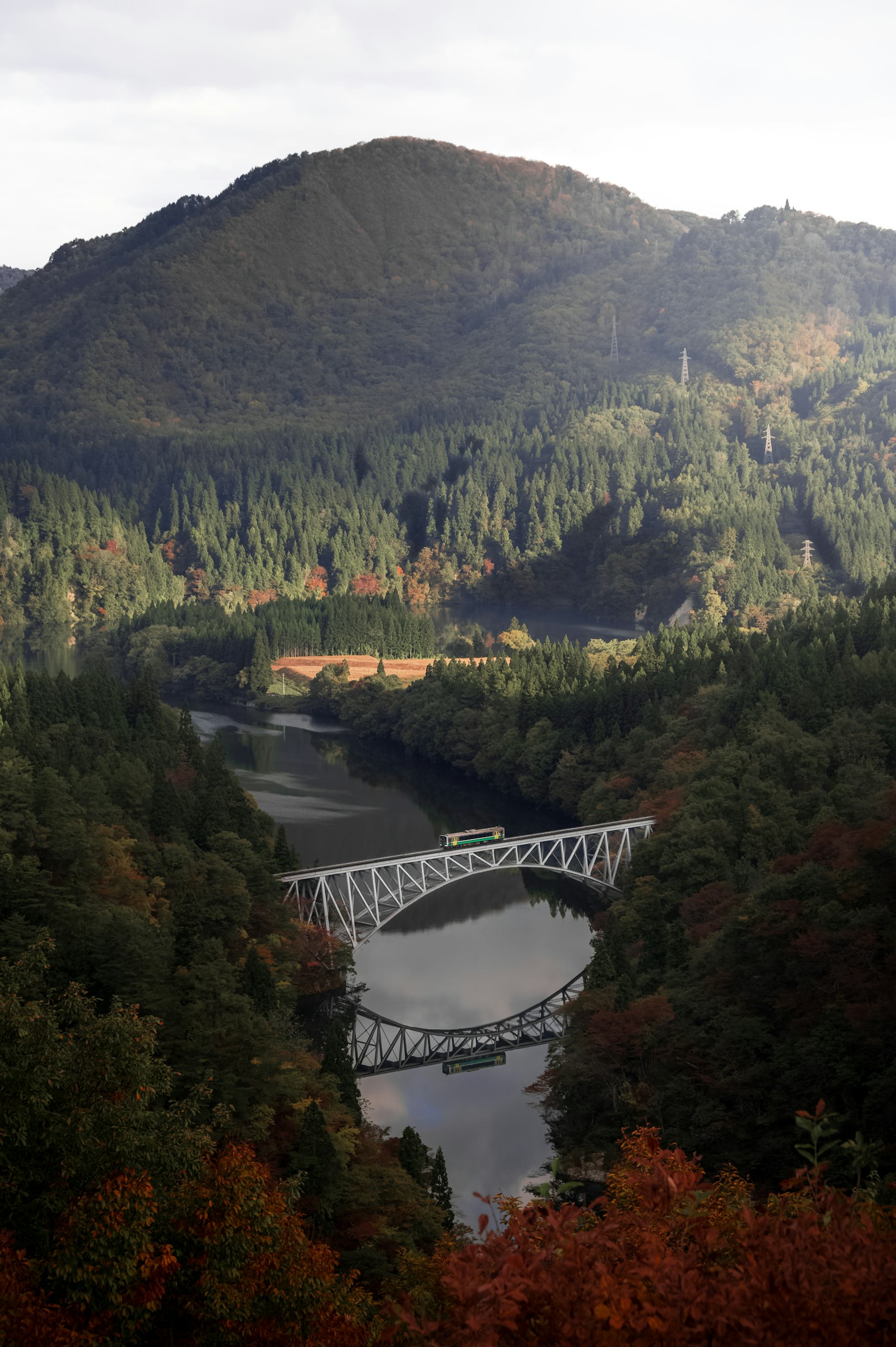 秋天山脈和河流背景下的白色橋樑風景