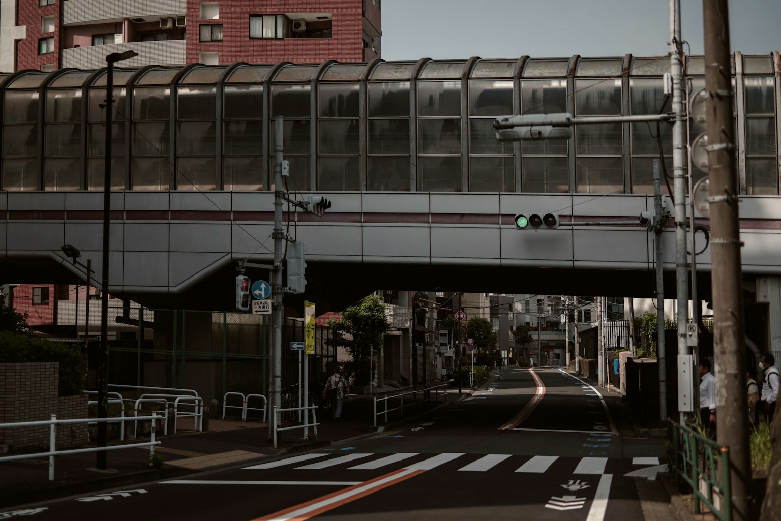 Quiet street under an overpass with traffic lights