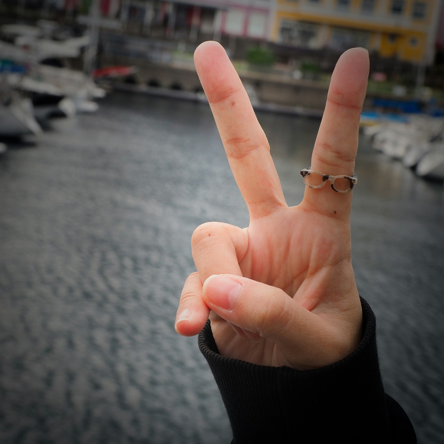 Eine Hand, die ein Friedenszeichen zeigt, mit einem Ring an einem Finger