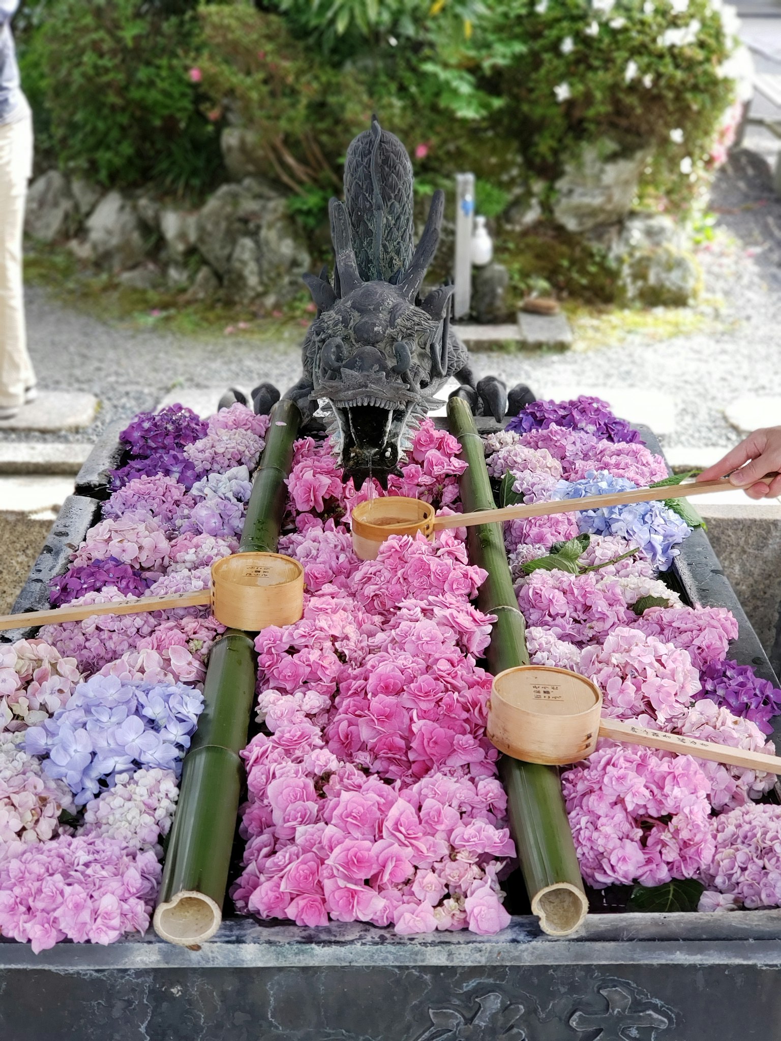 A shrine altar decorated with colorful flowers and bamboo water basins
