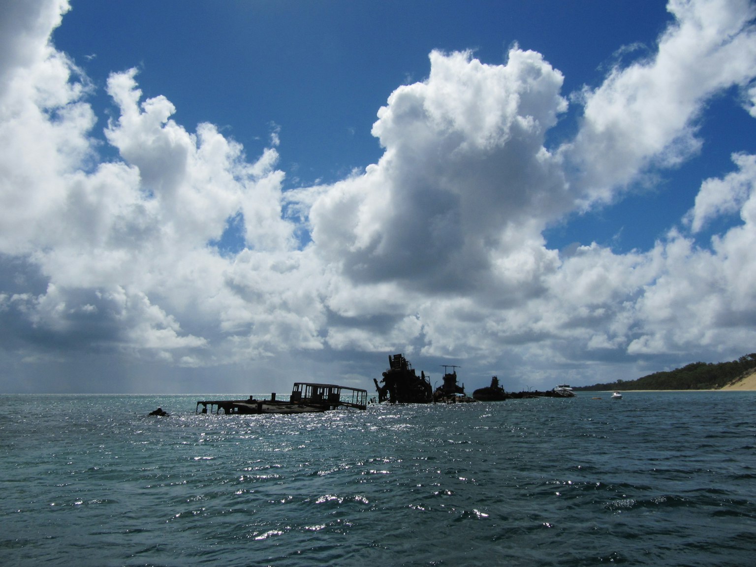 Barco hundido en el agua con nubes dramáticas