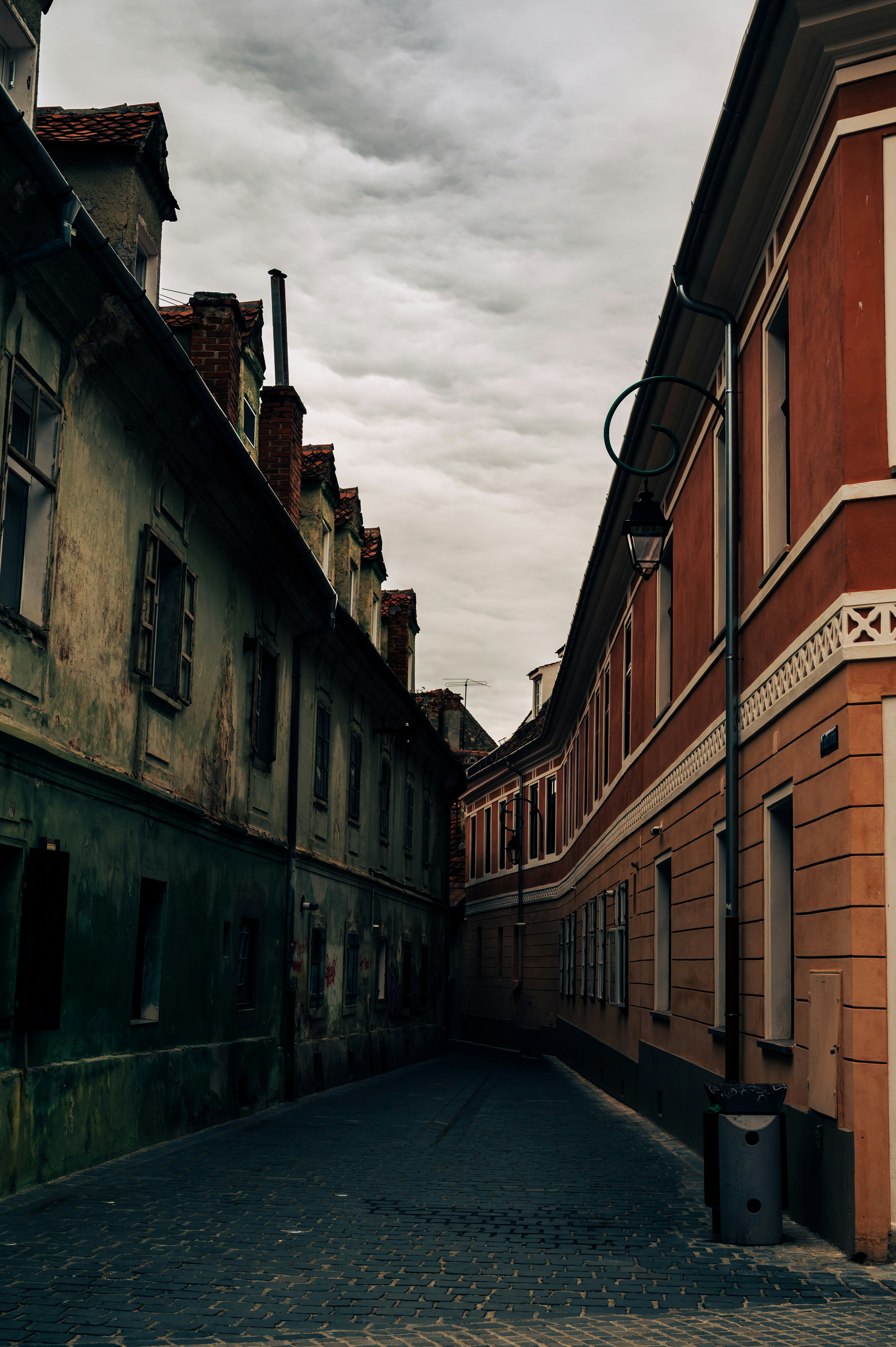 Overcast alley in Romania’s old town lined with buildings