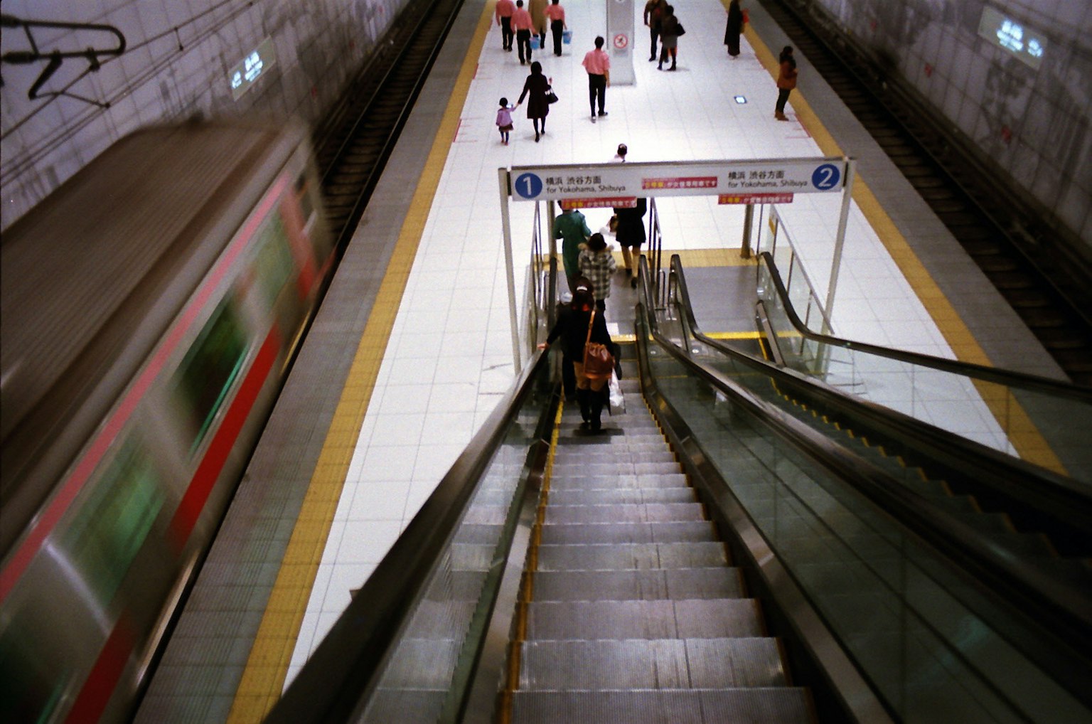 Scale mobili in una stazione della metropolitana con passeggeri