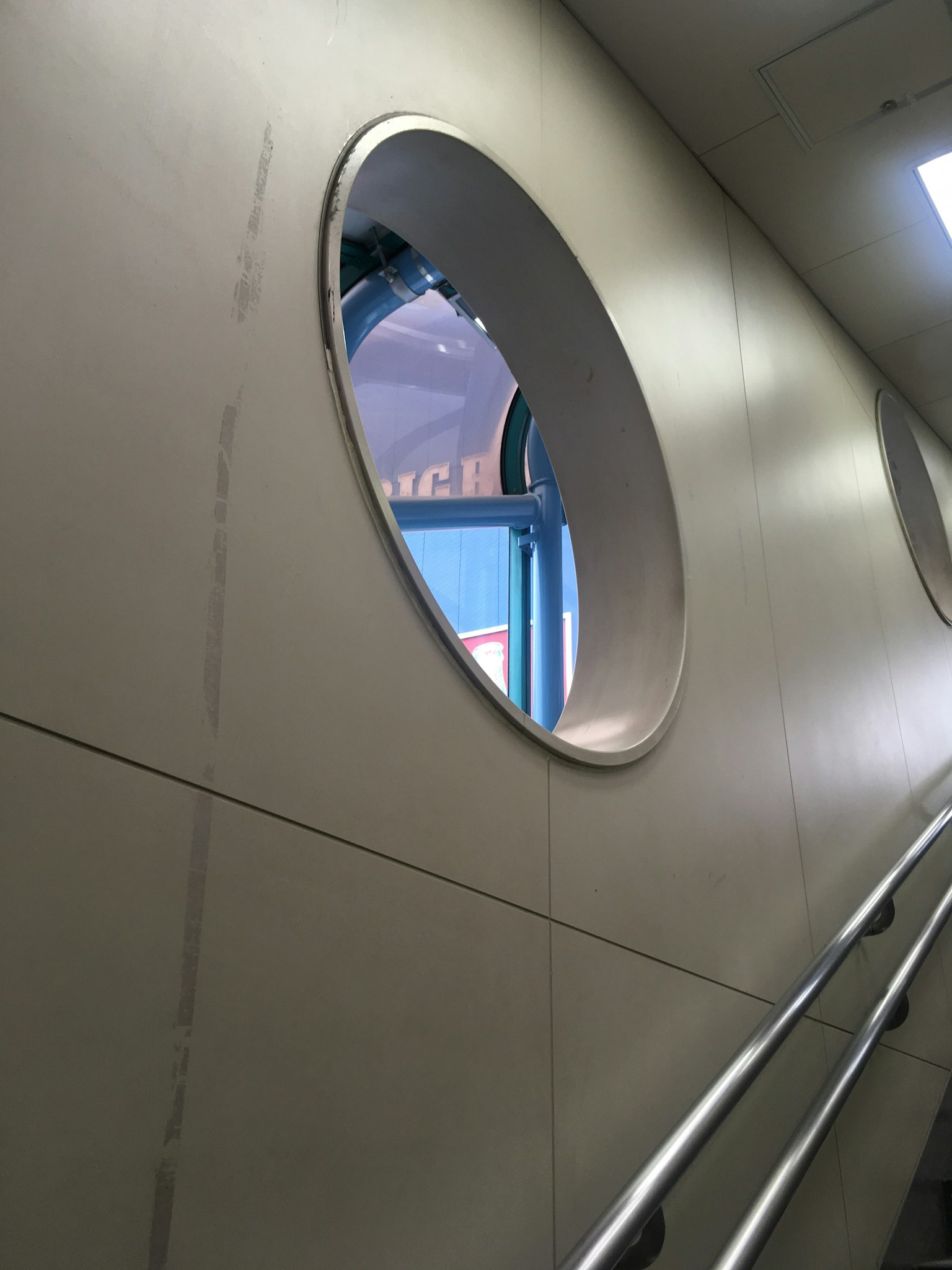 Scala interna con una finestra rotonda in un muro bianco
