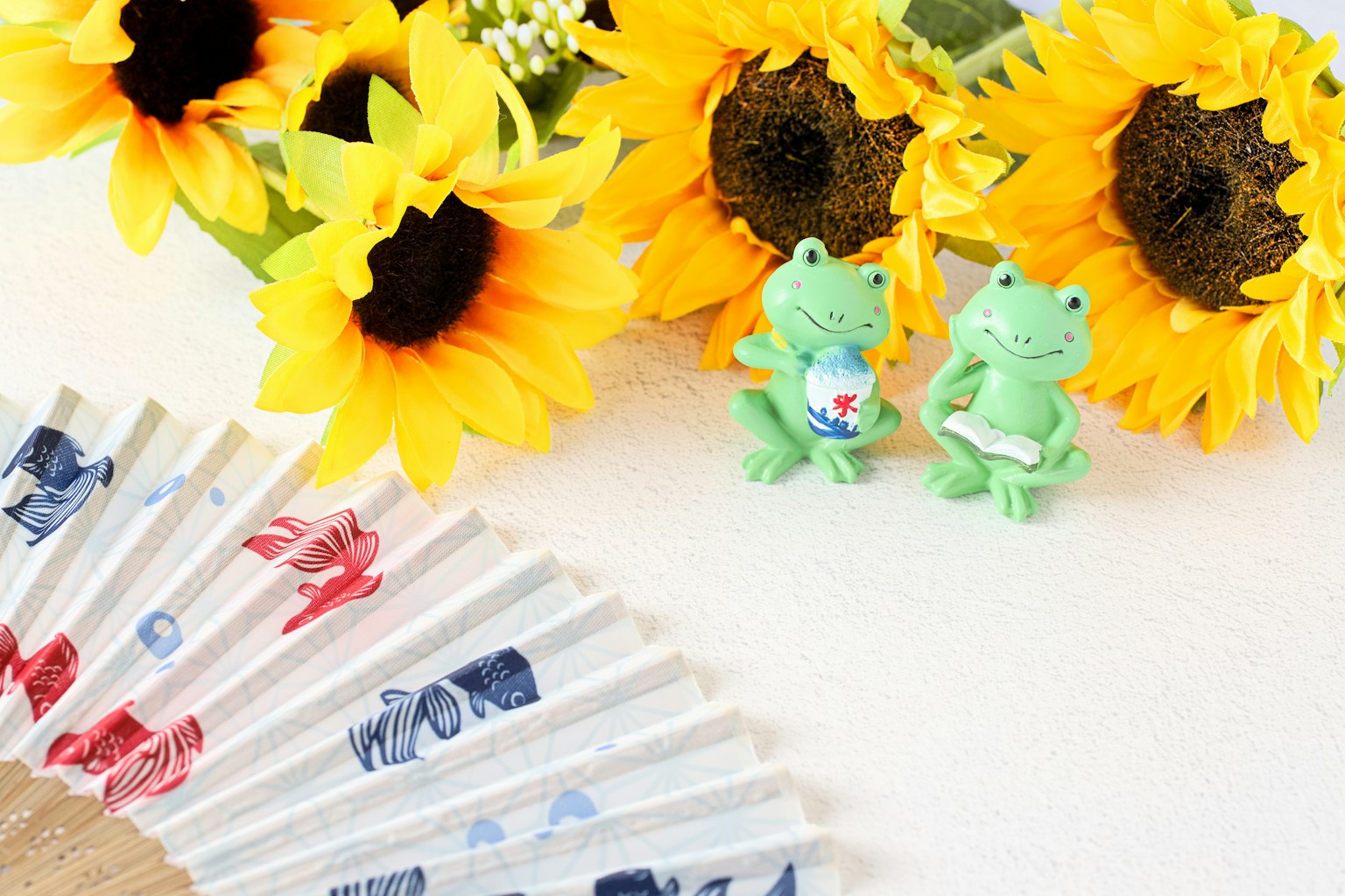 Girasoles vibrantes y figuritas de ranas verdes dispuestas en un entorno tranquilo