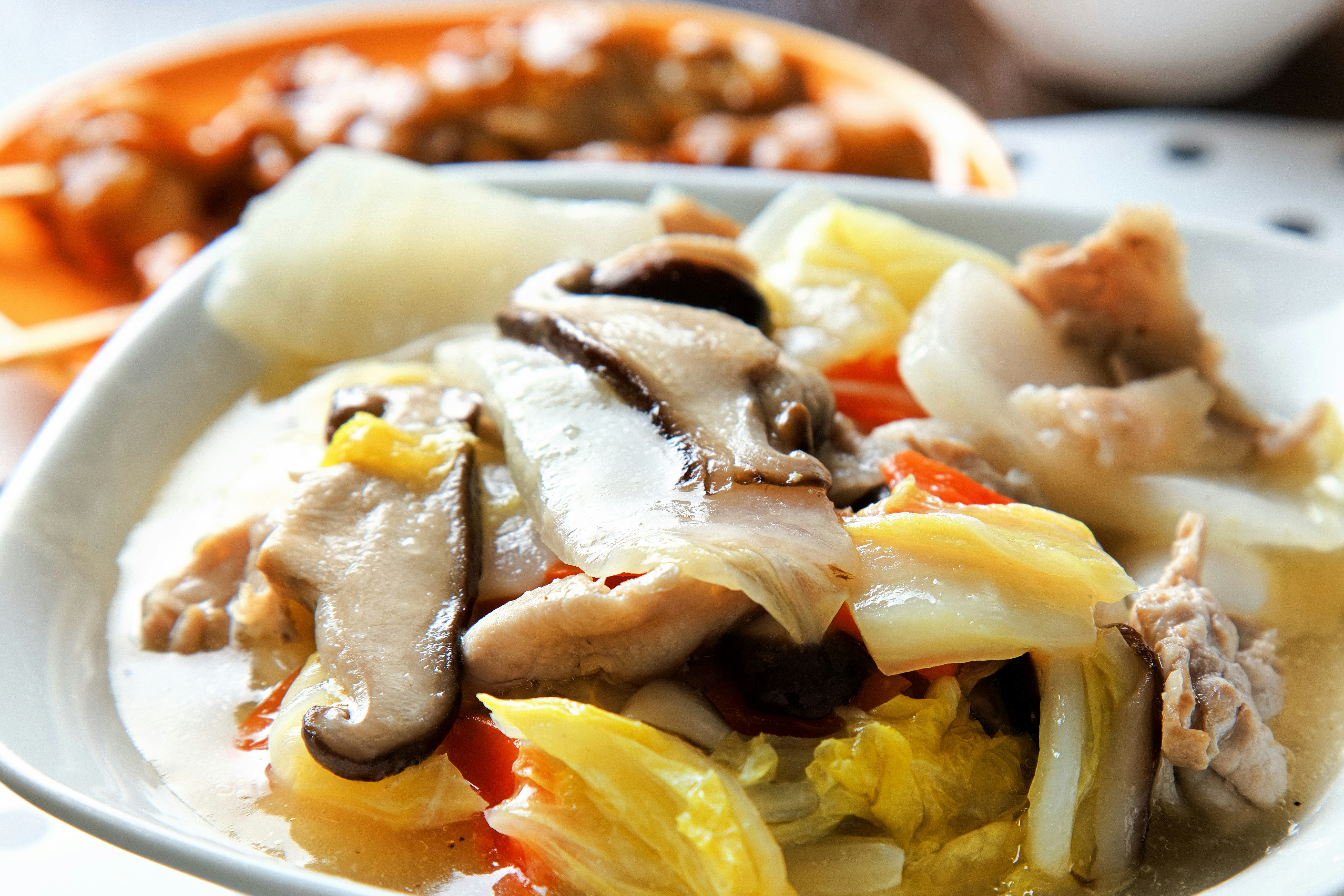 白い皿に盛られた色鮮やかな野菜と鶏肉の料理
