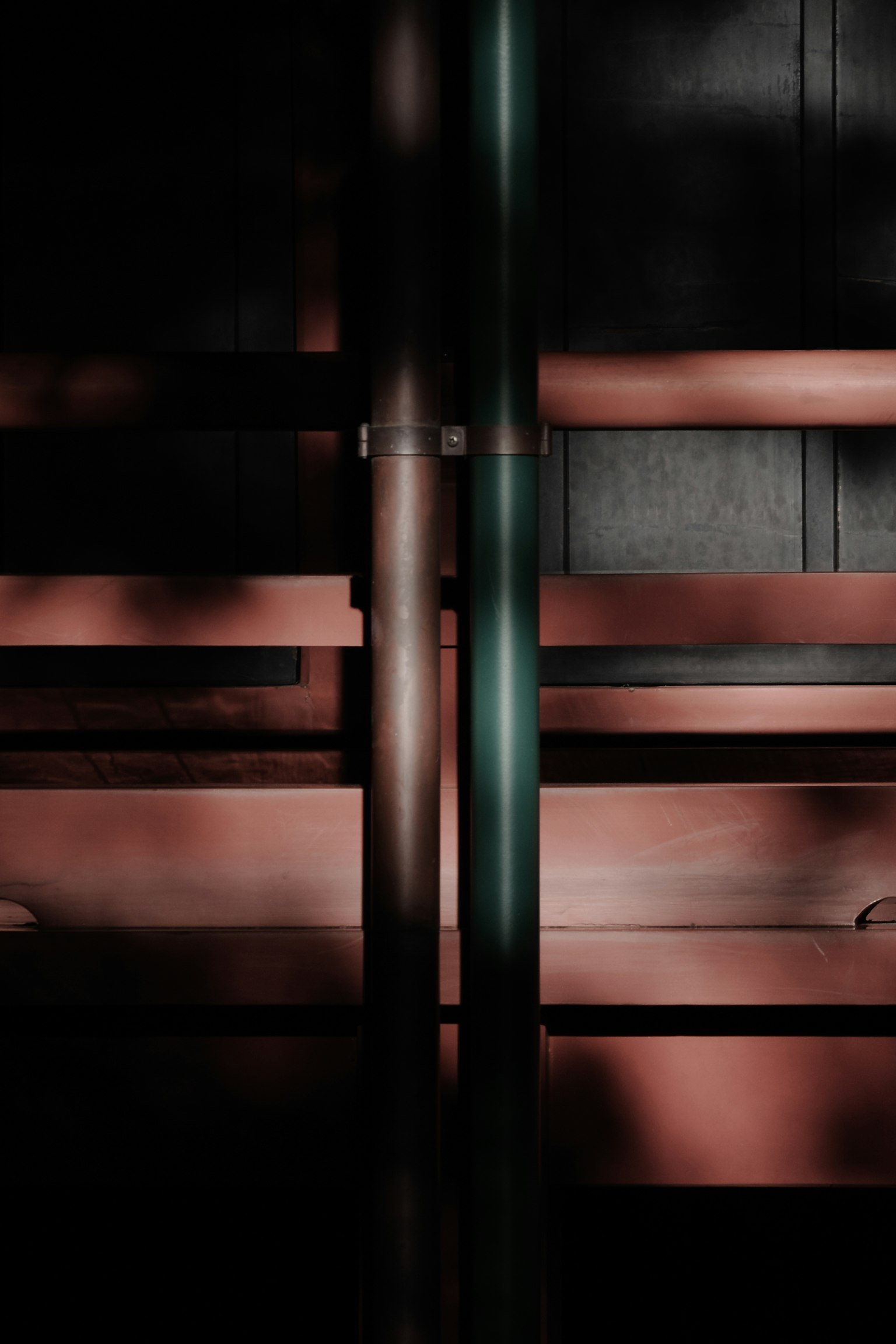 Composizione astratta con tubi metallici che si intrecciano su uno sfondo scuro e texture di legno