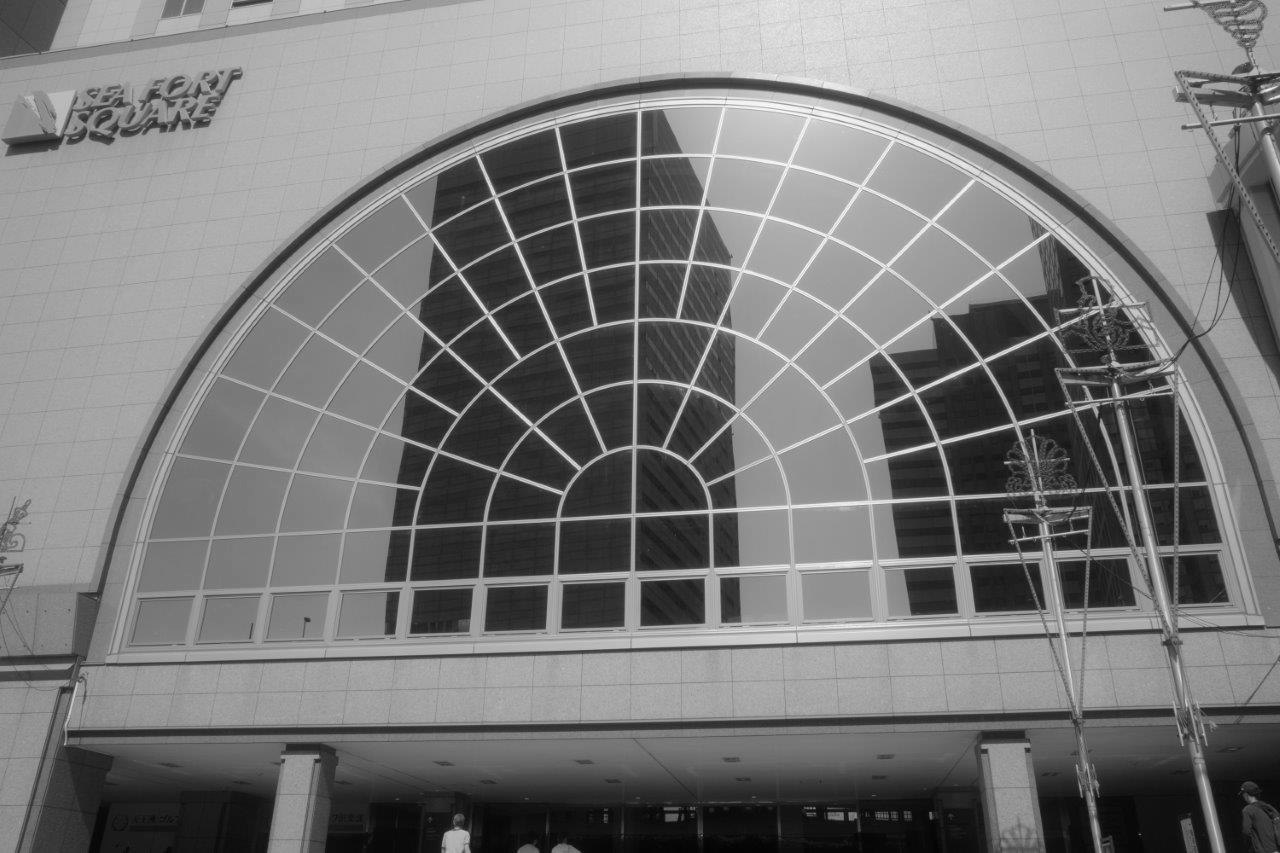 entrée vitrée en arc et façade à motifs en grille