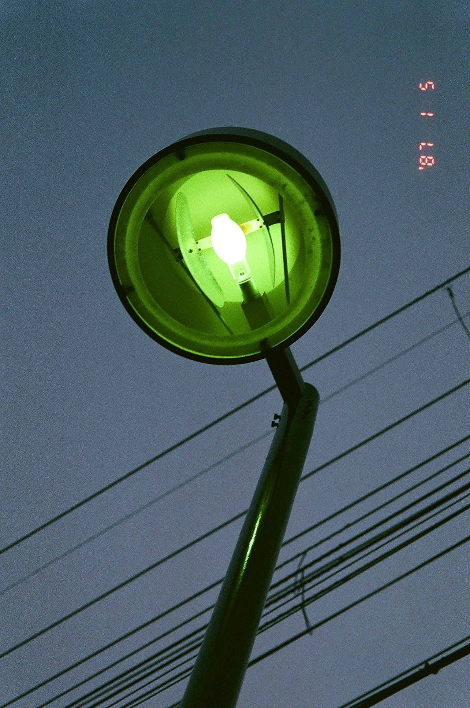 Farola verde de pie contra el cielo