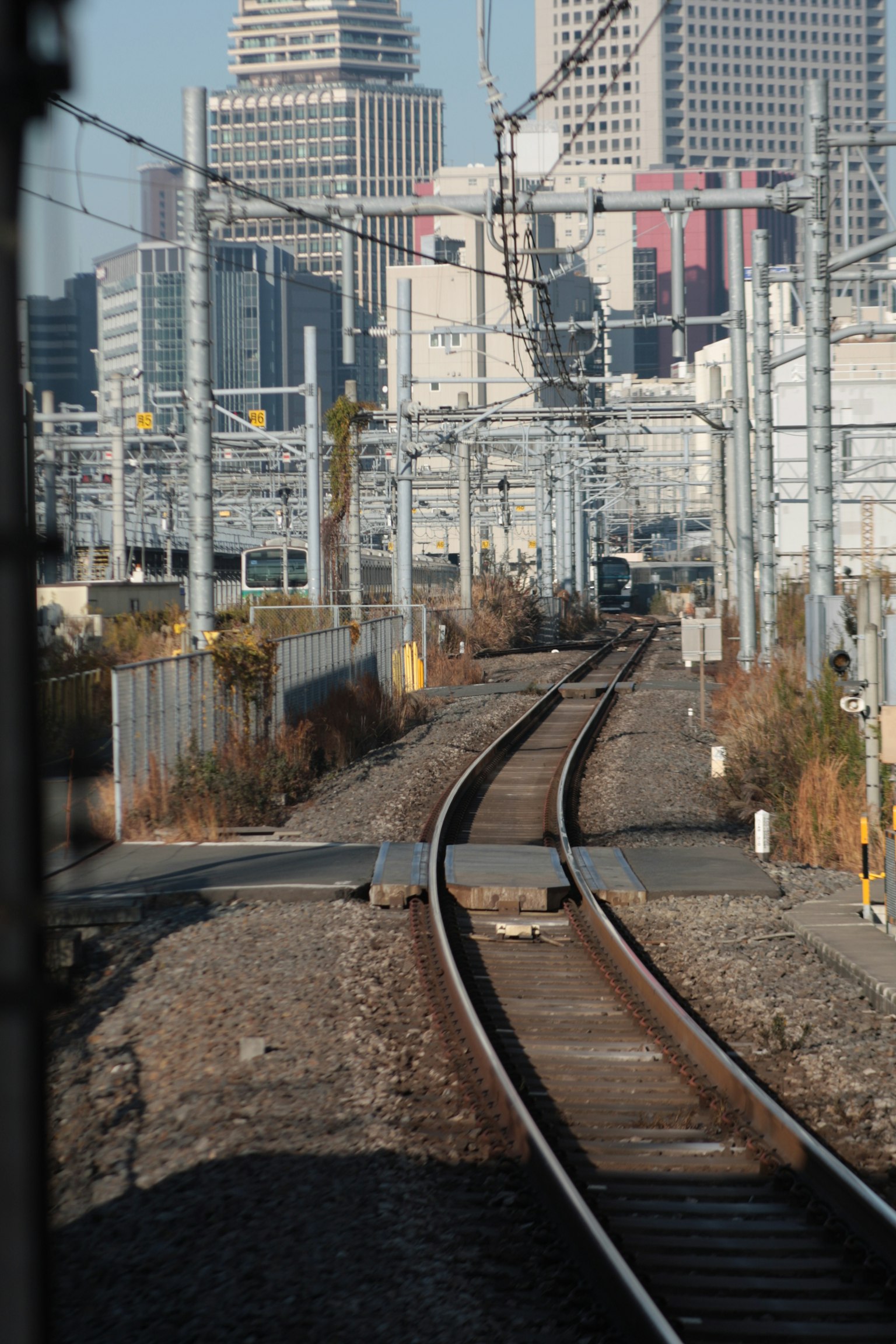 Binari ferroviari con skyline urbano sullo sfondo
