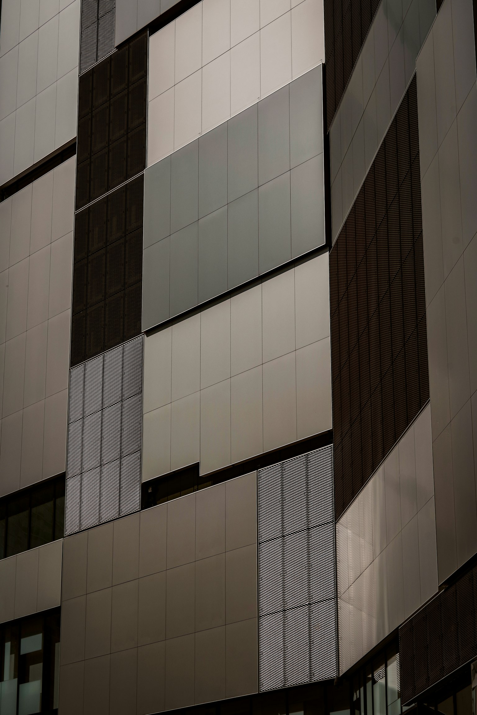 Close-up of a modern building facade featuring various panels in different shades