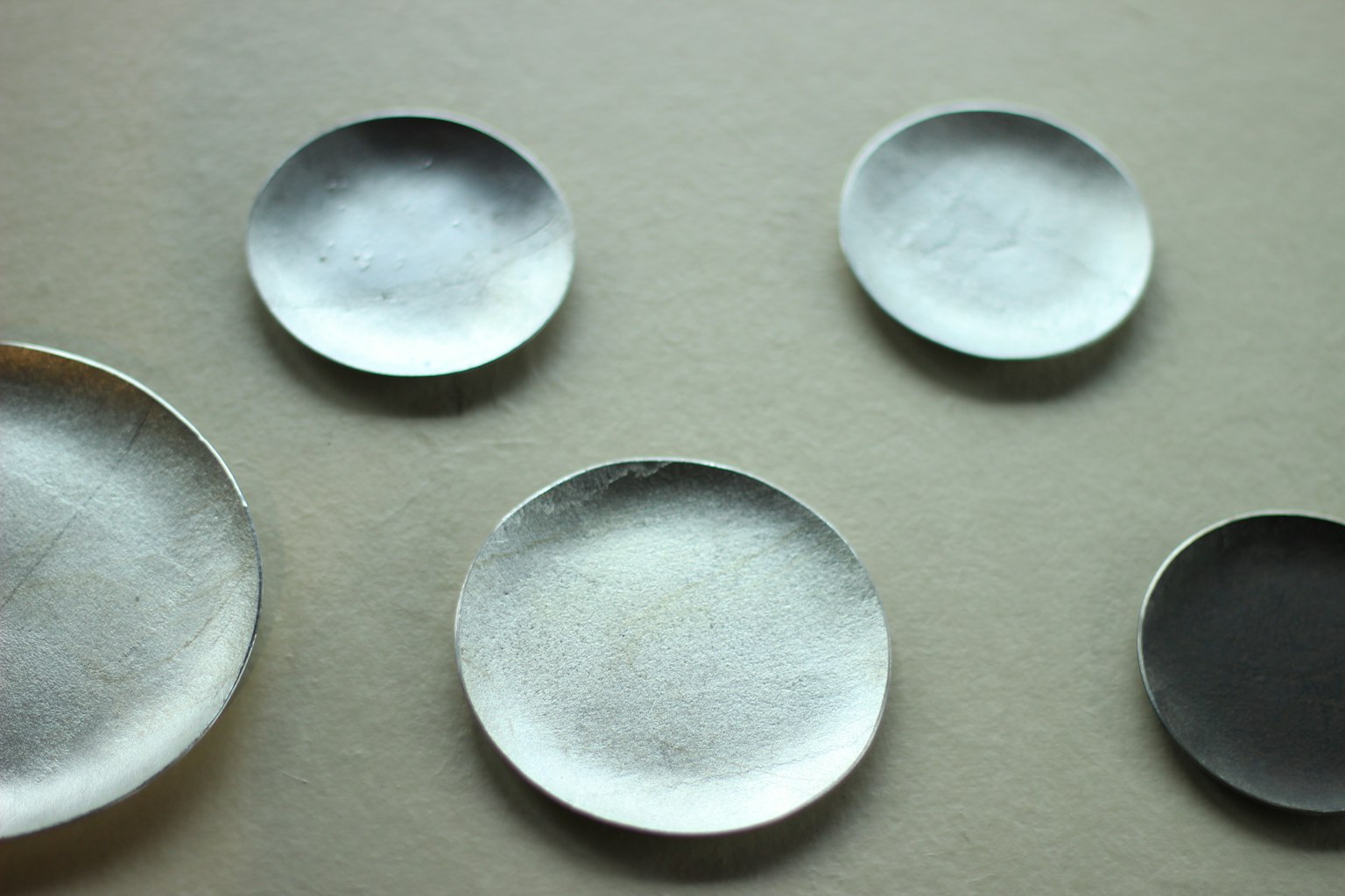 A collection of silver plates in various sizes arranged artistically