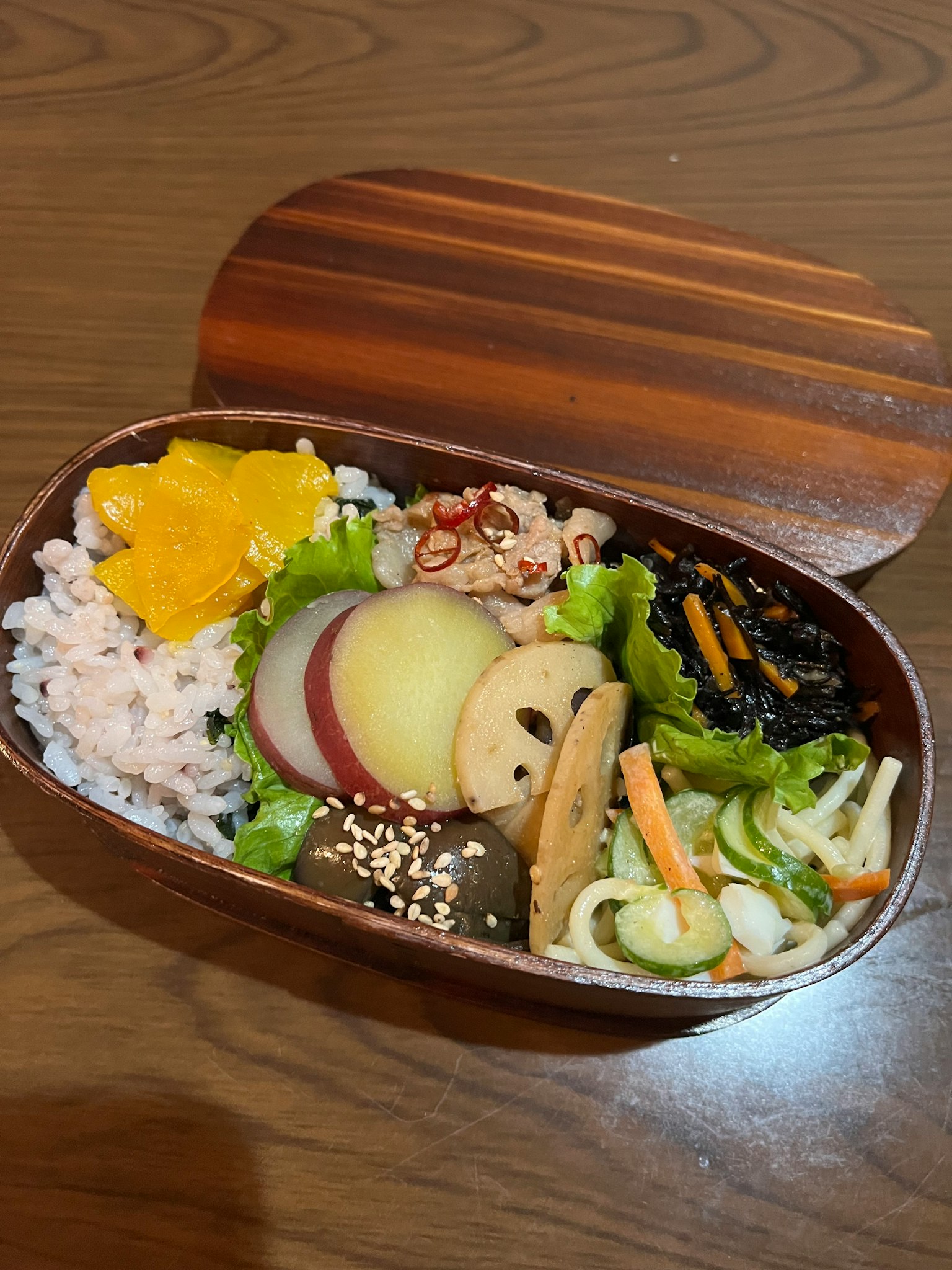 木制便当盒装满色彩缤纷的菜肴和米饭