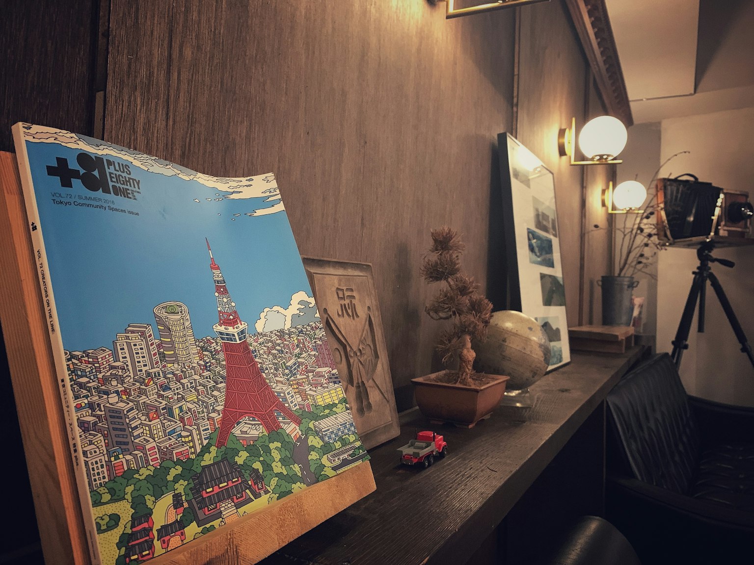Ein Buch mit einer Illustration des Tokyo Tower und dekorativen Gegenständen sowie einer Kamera in der Nähe