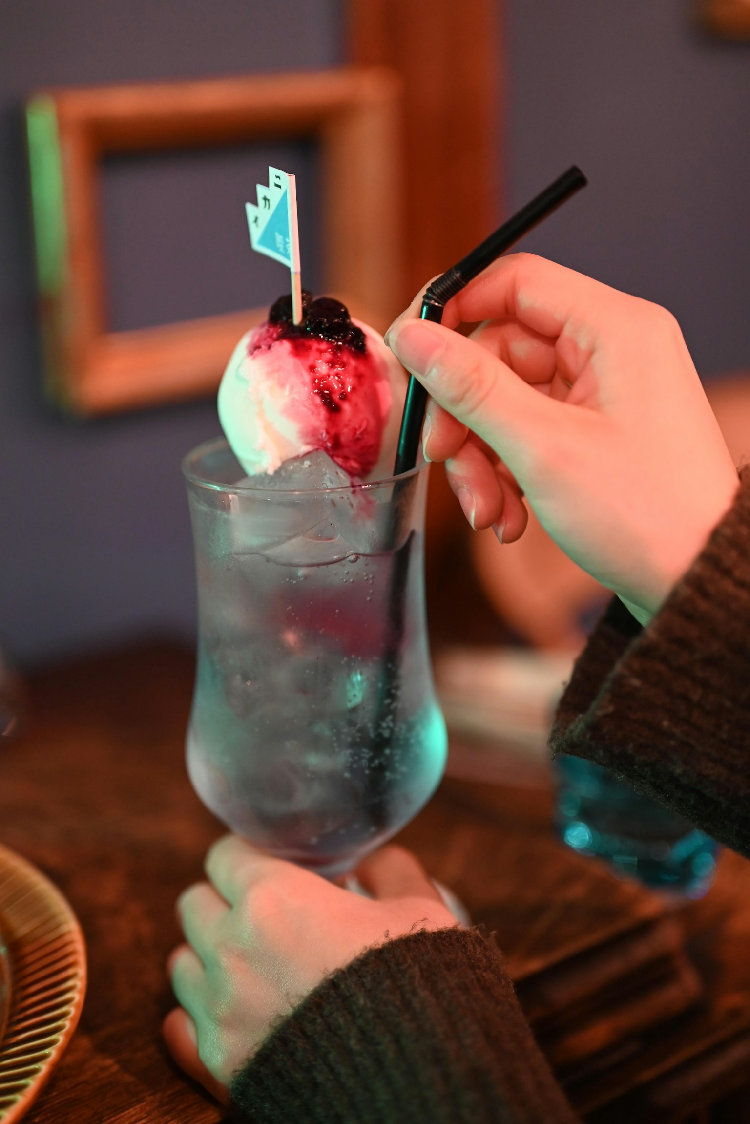 Un bicchiere di cocktail guarnito con gelato tenuto da una mano