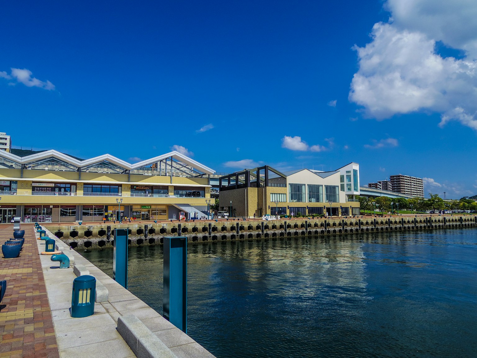 Modern buildings along a waterfront under a clear blue sky