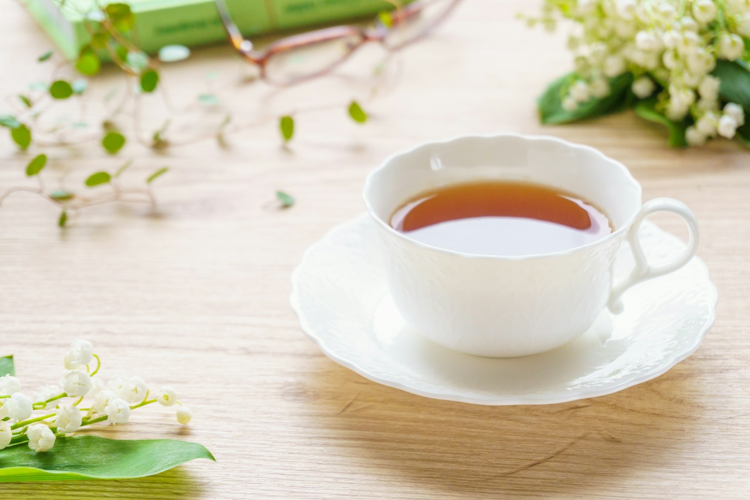 Tazza bianca con tè circondata da fiori