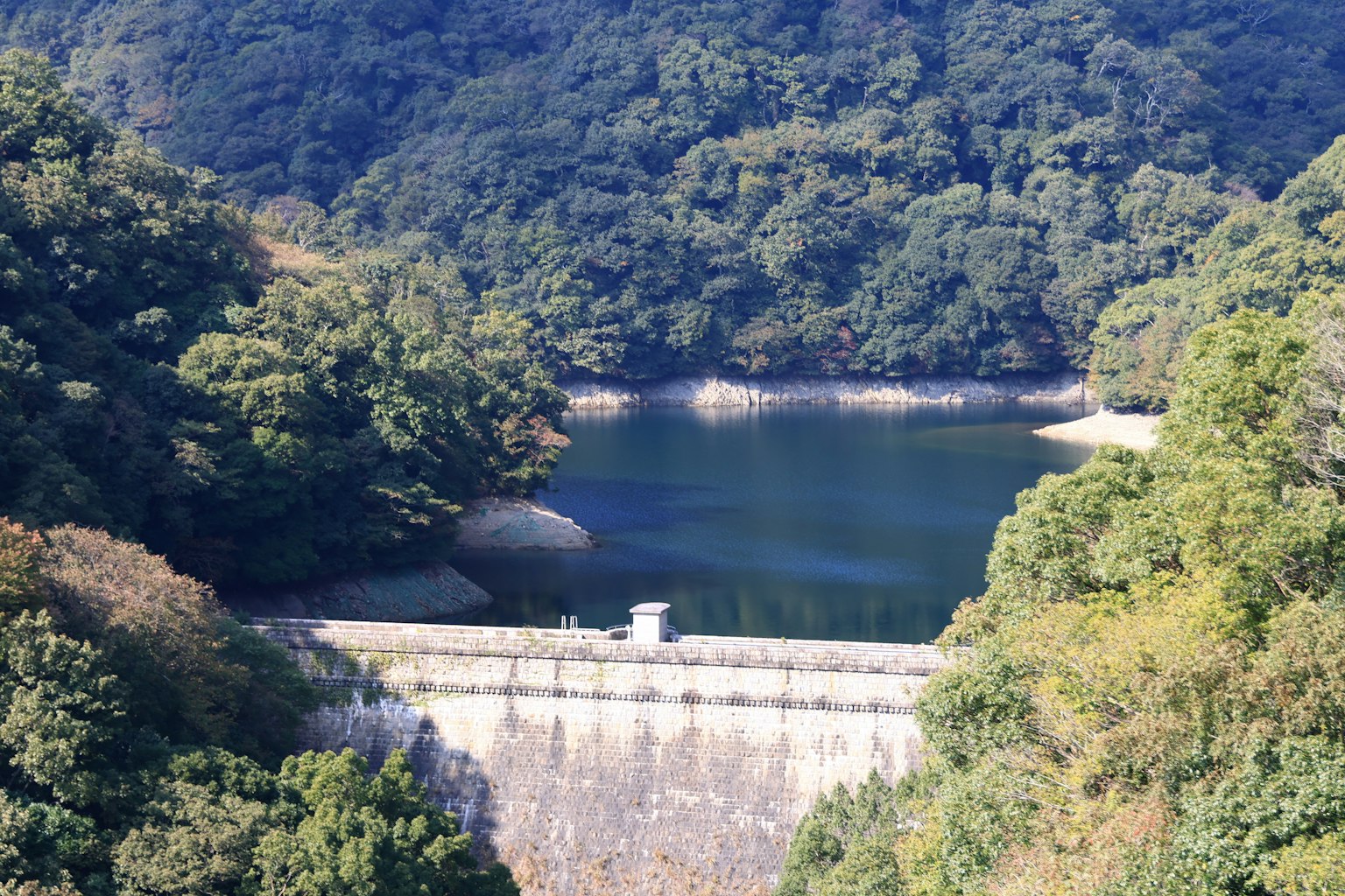 Vista escénica de una presa y un lago rodeados de montañas