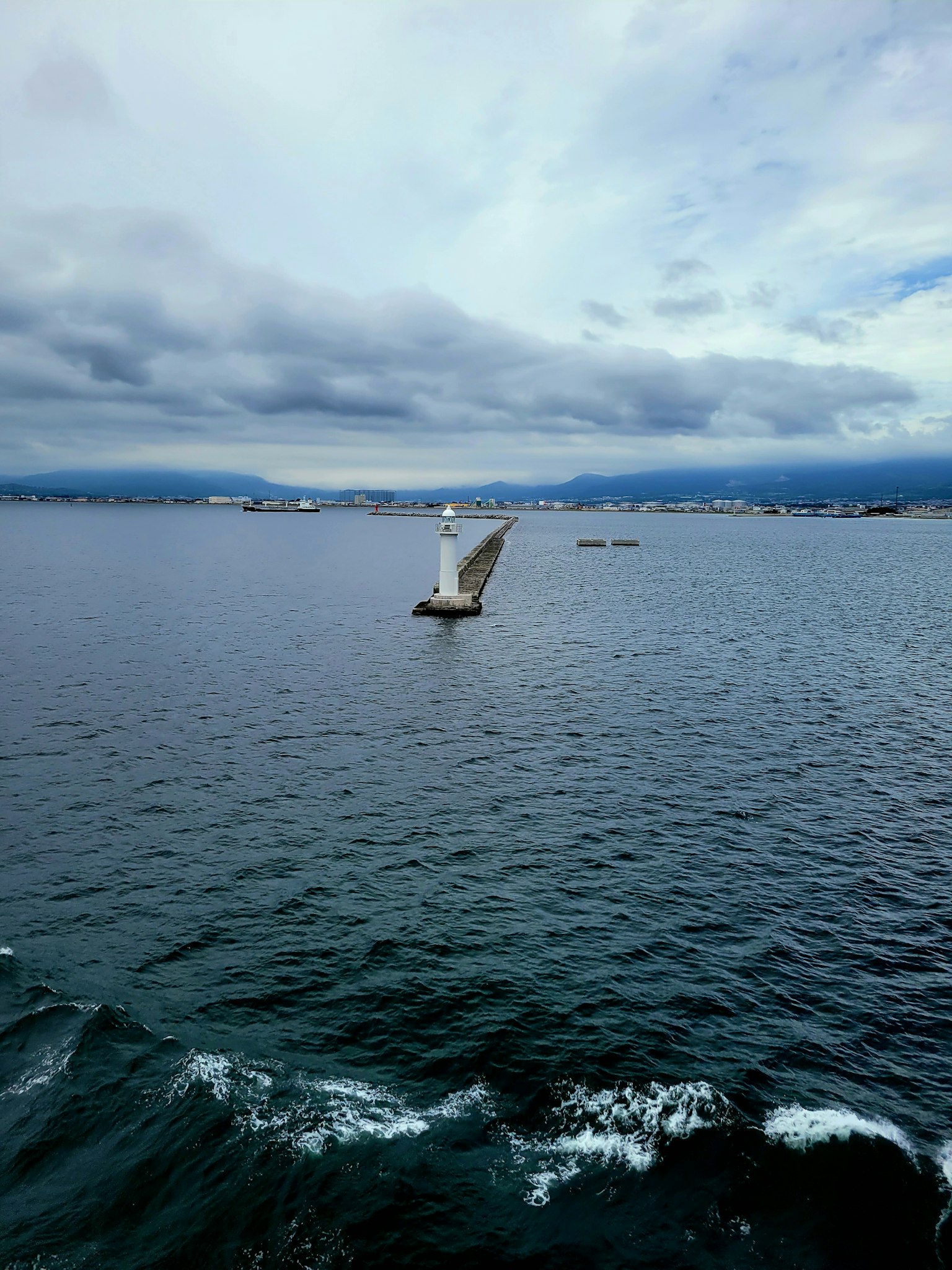 一艘帆船在水面上滑行，天空多雲