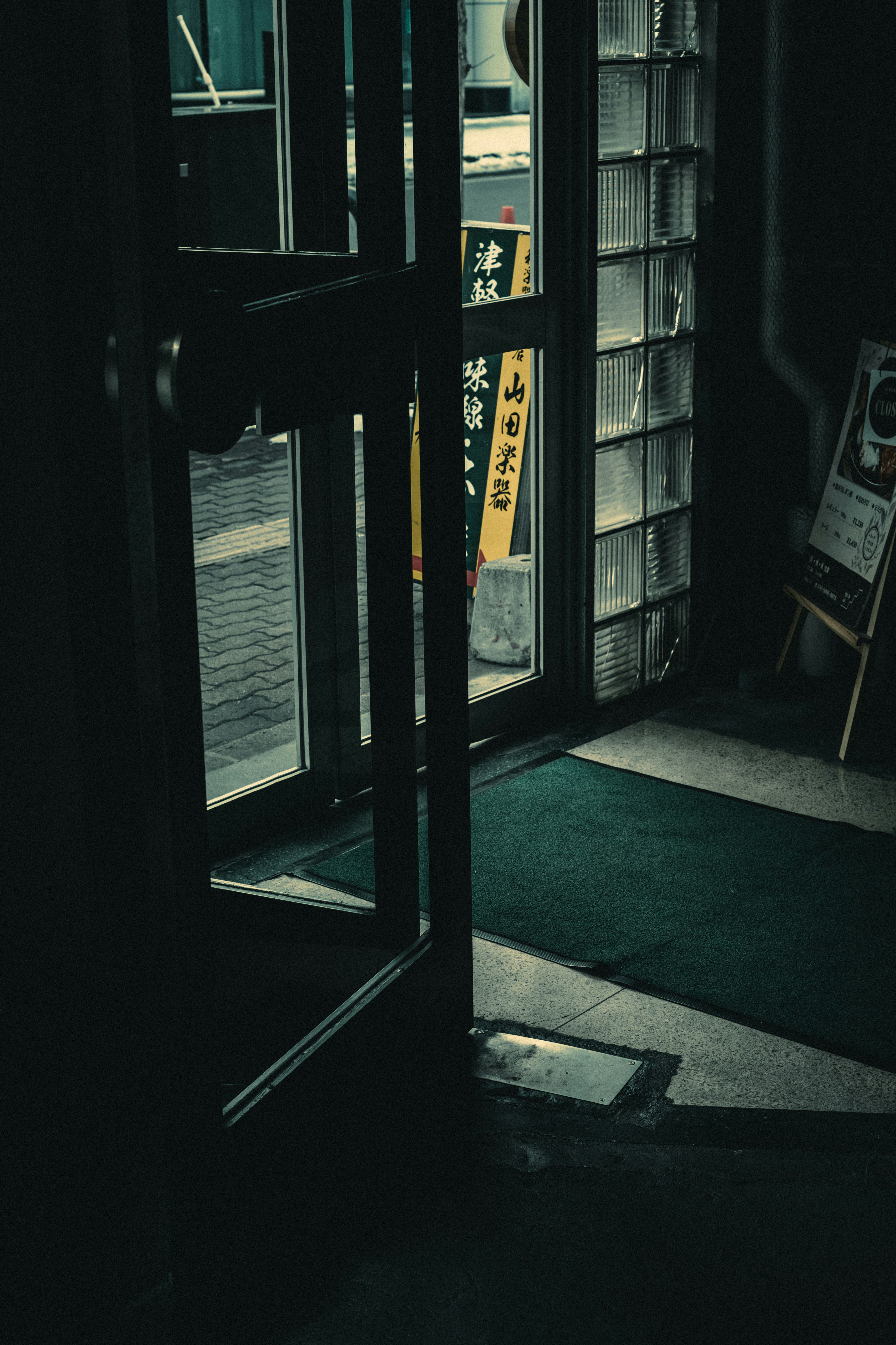 暗い入口のドアが開いている内部の風景 照明が柔らかく床が見える
