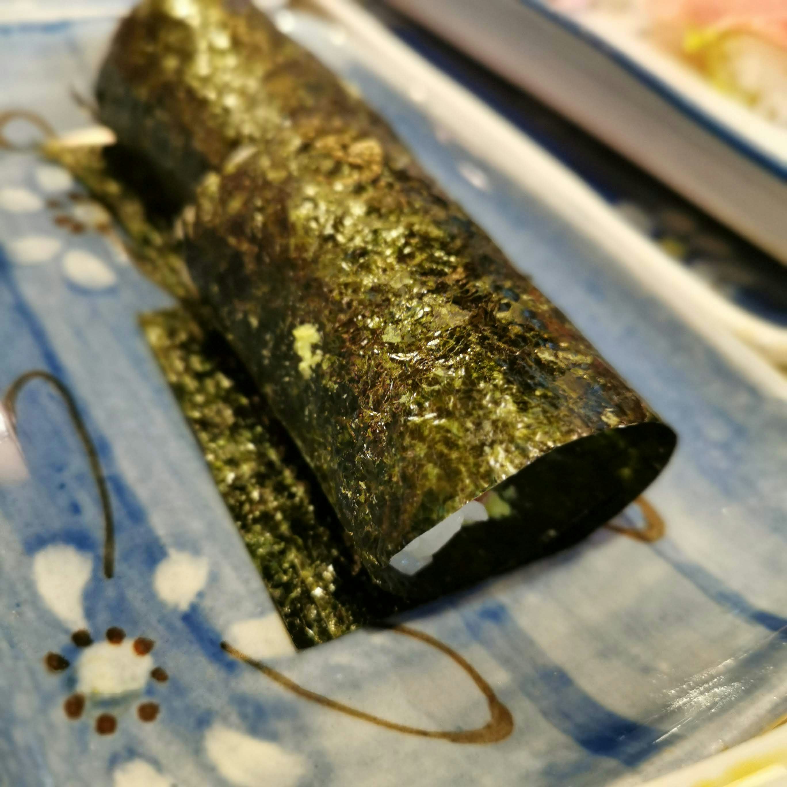 青い布の上に置かれた金色の筒状の物体