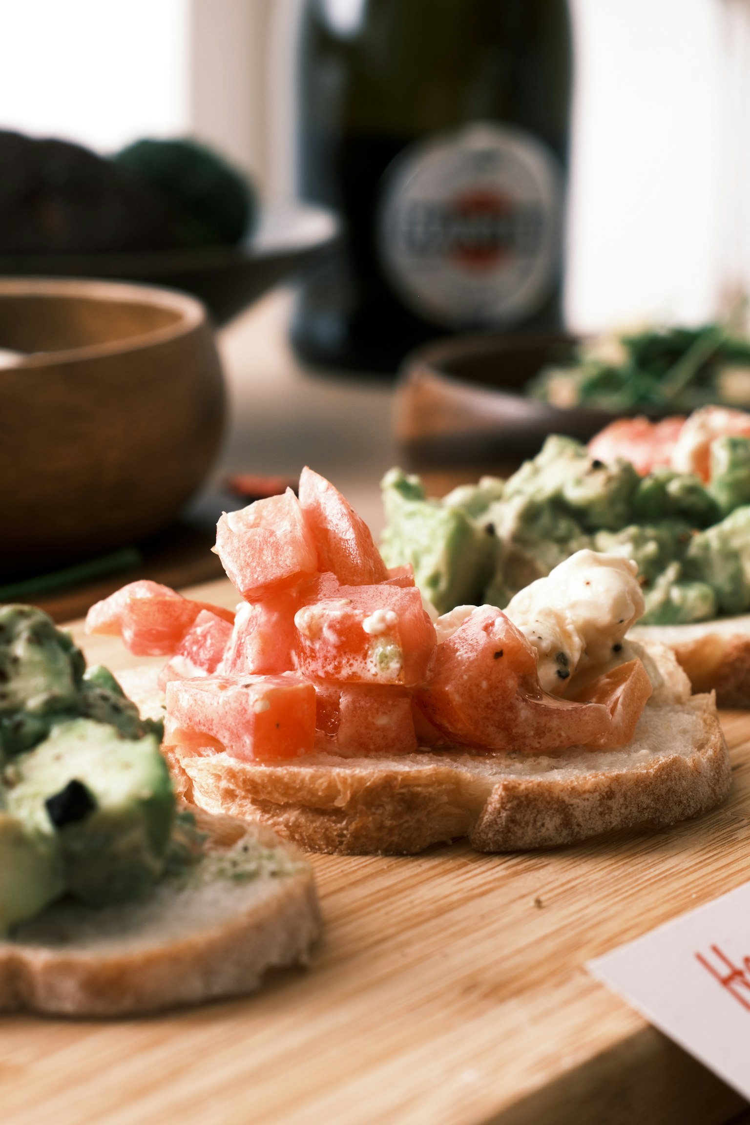 Tostada tomat dan alpukat segar disusun di atas papan kayu