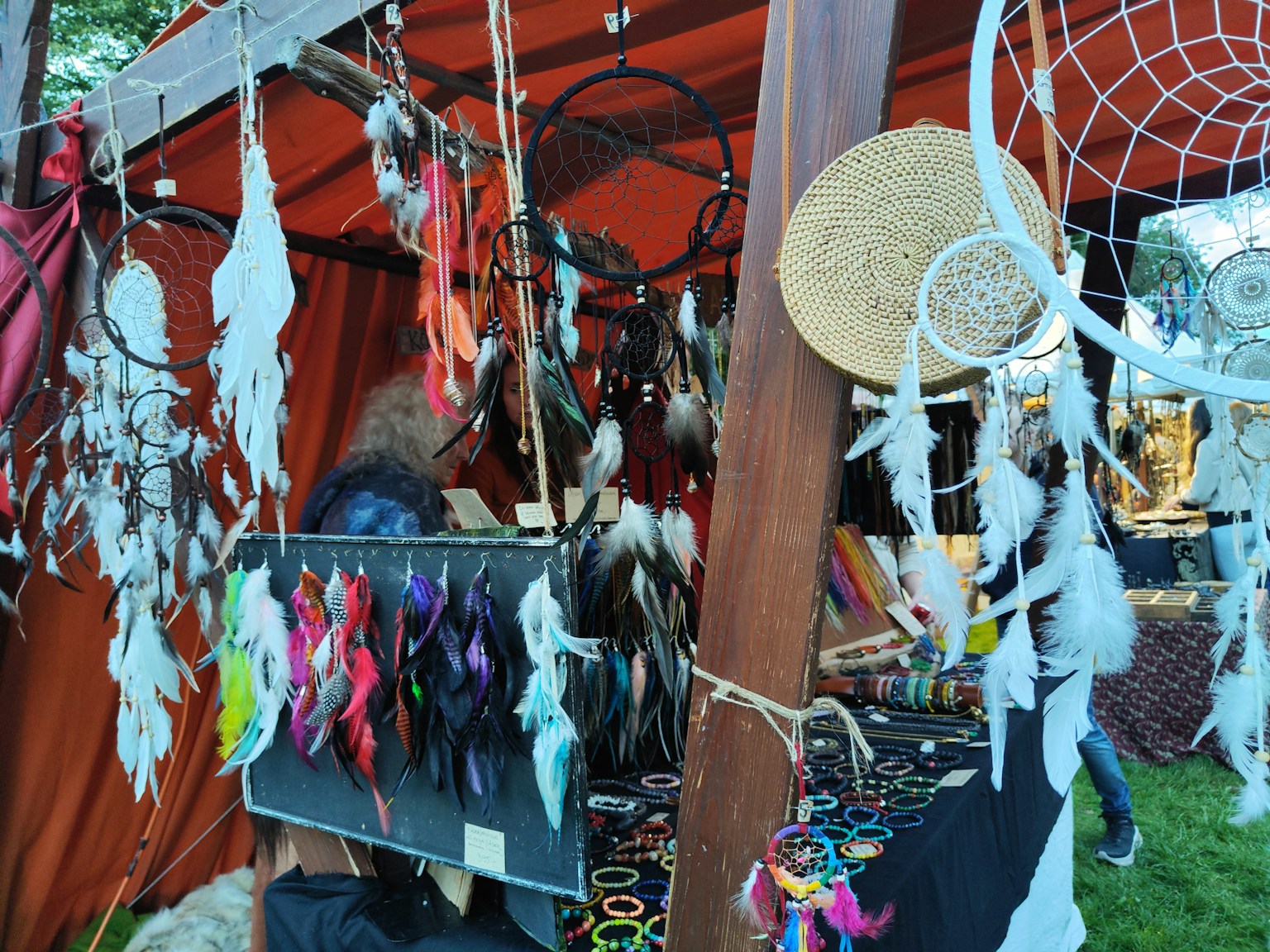 Attrape-rêves colorés et ornements en plumes exposés à un stand de marché