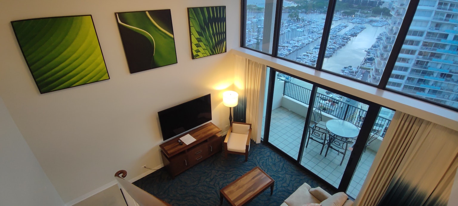 View from above of a high-rise apartment living room large windows allowing natural light green artwork on the walls