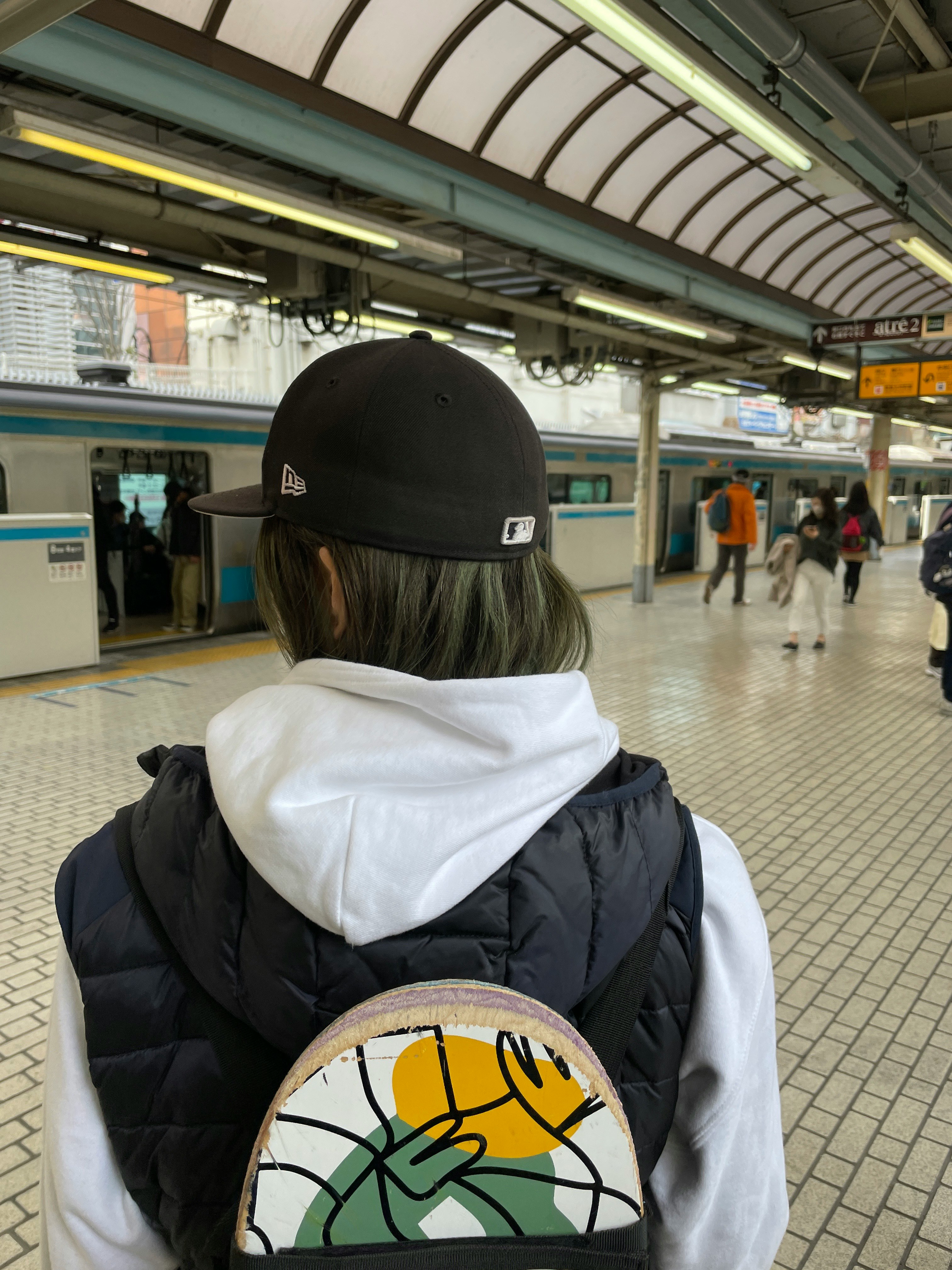 駅のホームで背中を見せる人物