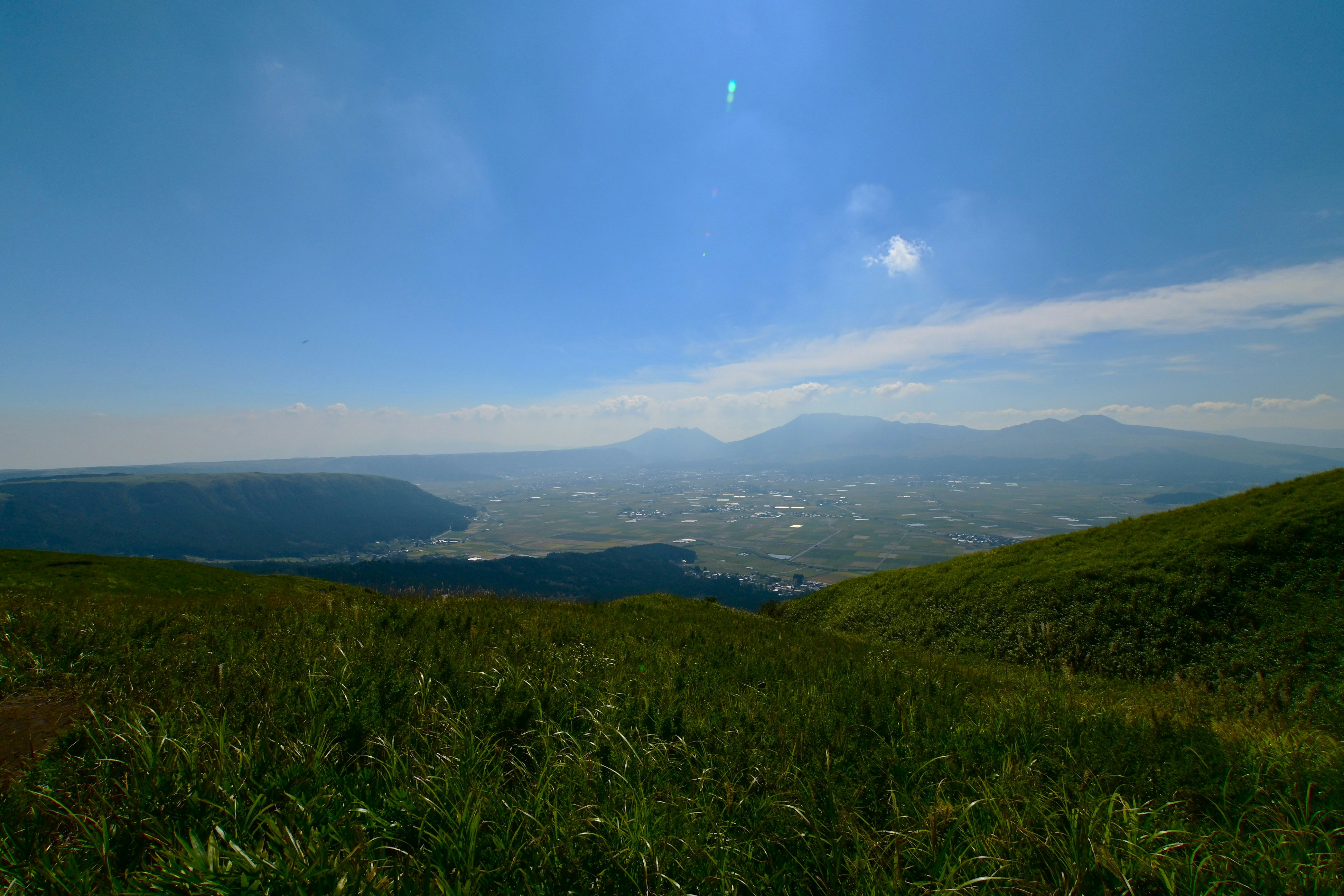 阿蘇の草原から望む山並みと谷の眺望