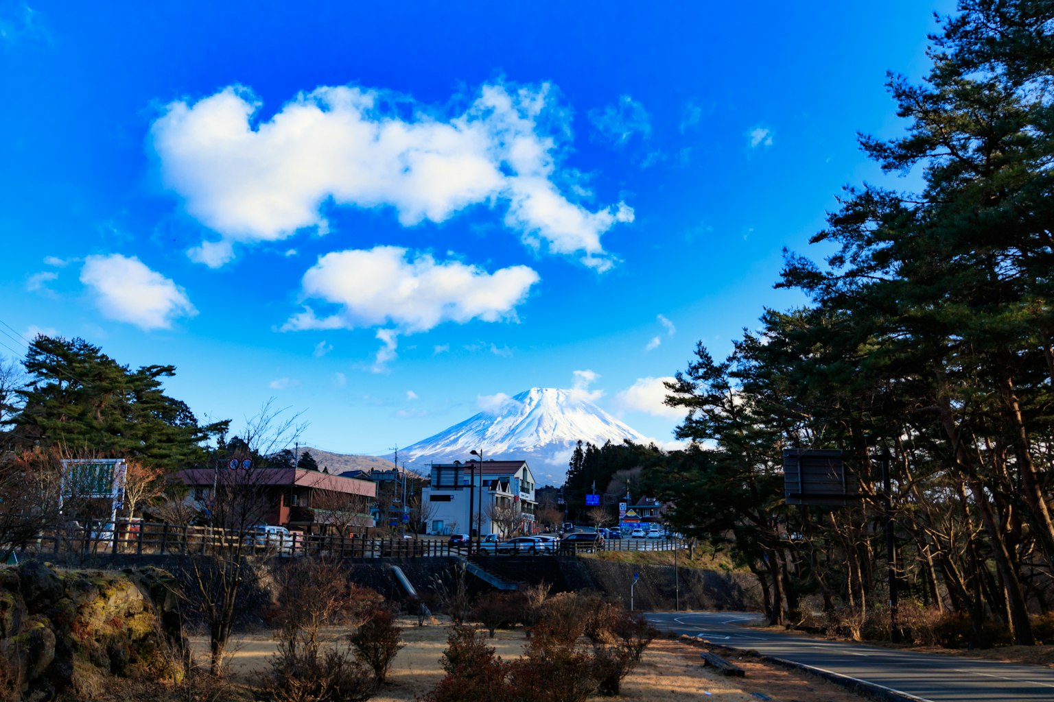 ทิวทัศน์ที่สวยงามของภูเขาฟูจิใต้ท้องฟ้าสีฟ้าพร้อมเมฆขาวฟูฟ่อง