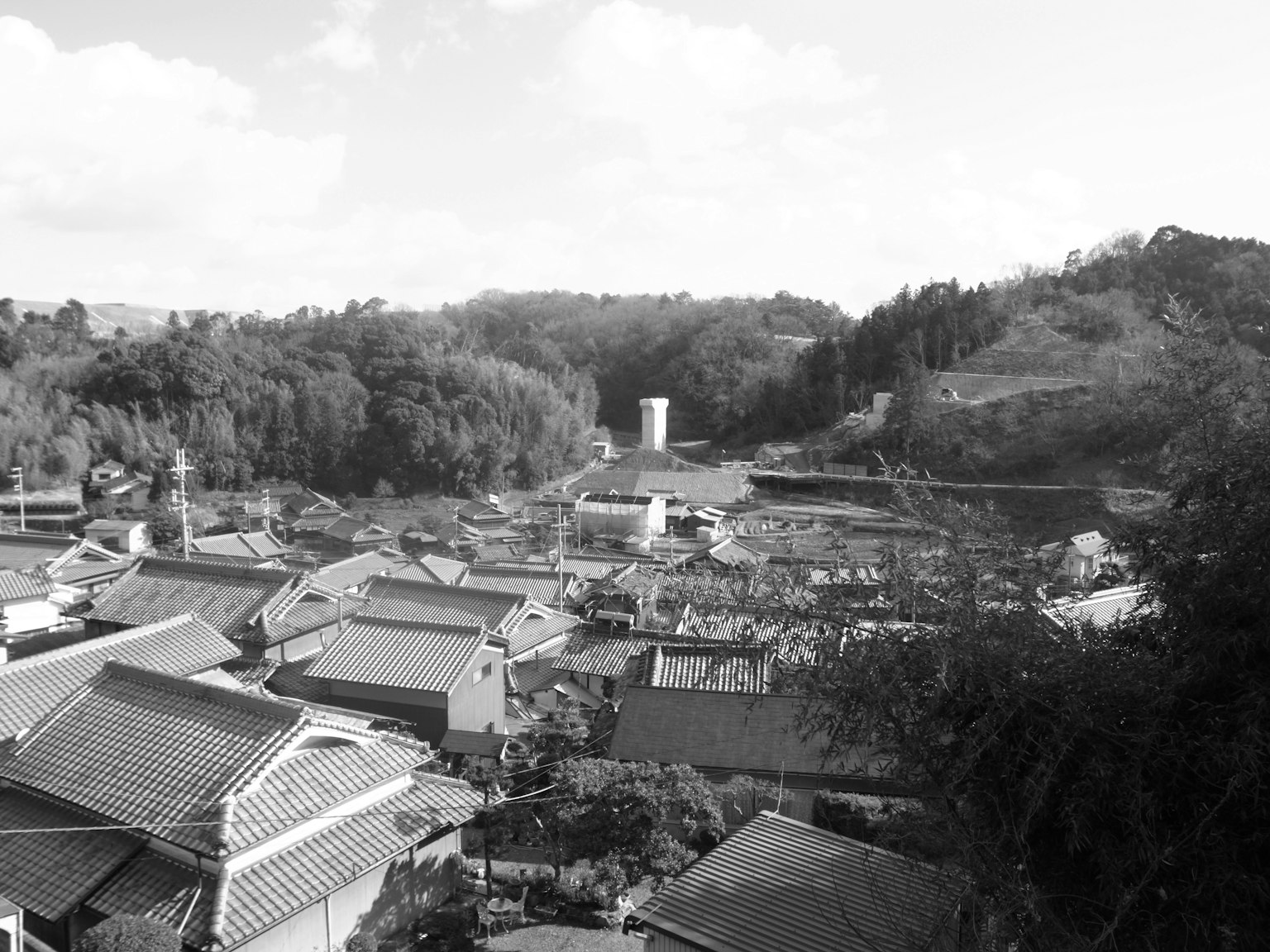 ทิวทัศน์หมู่บ้านขาวดำที่ถูกล้อมรอบด้วยภูเขาพร้อมบ้านแบบดั้งเดิม