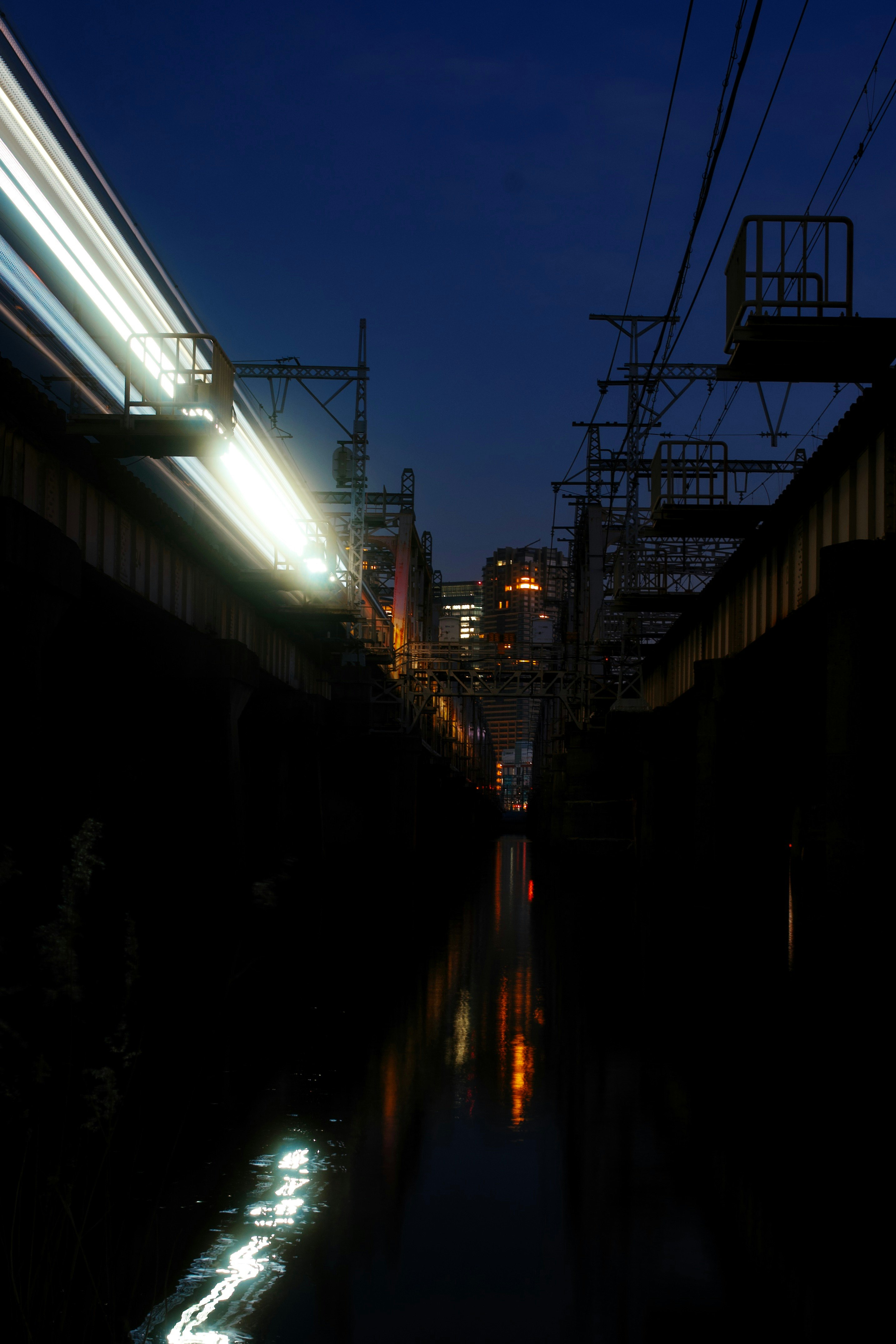 夜の路地に伸びる街灯と電線のある風景