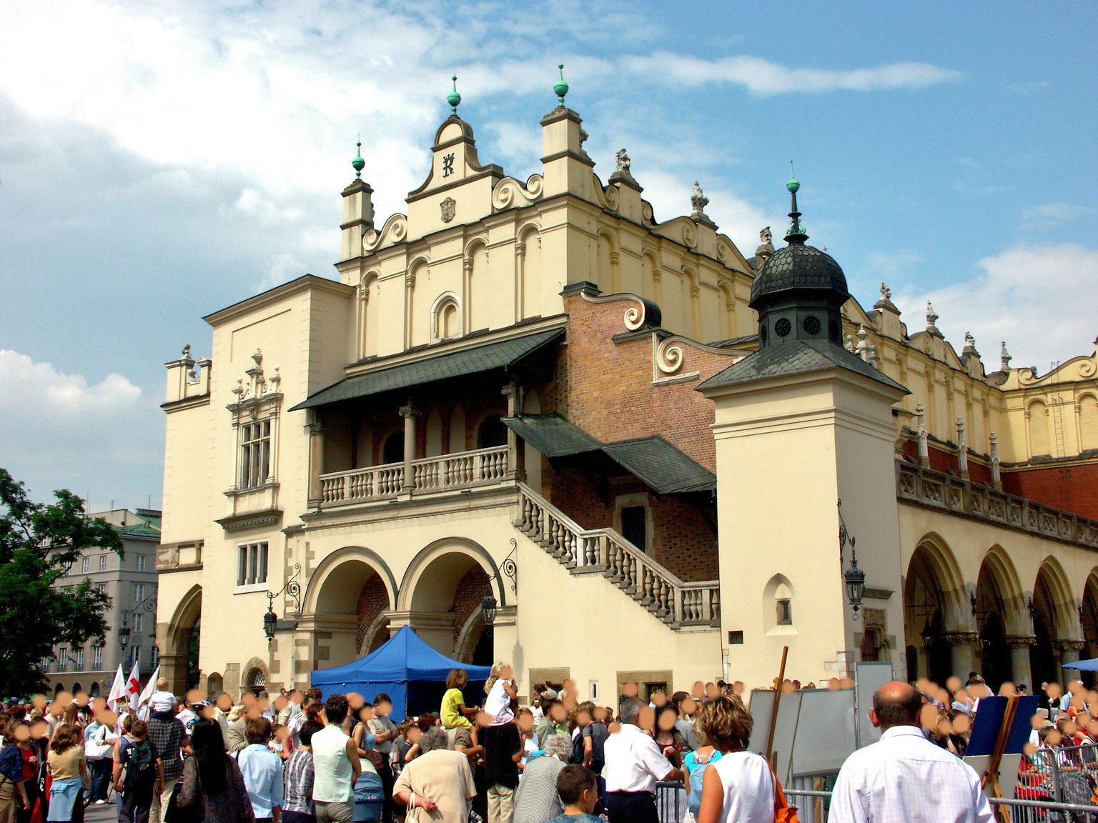 Edificio storico nella piazza del mercato di Cracovia con una folla di persone