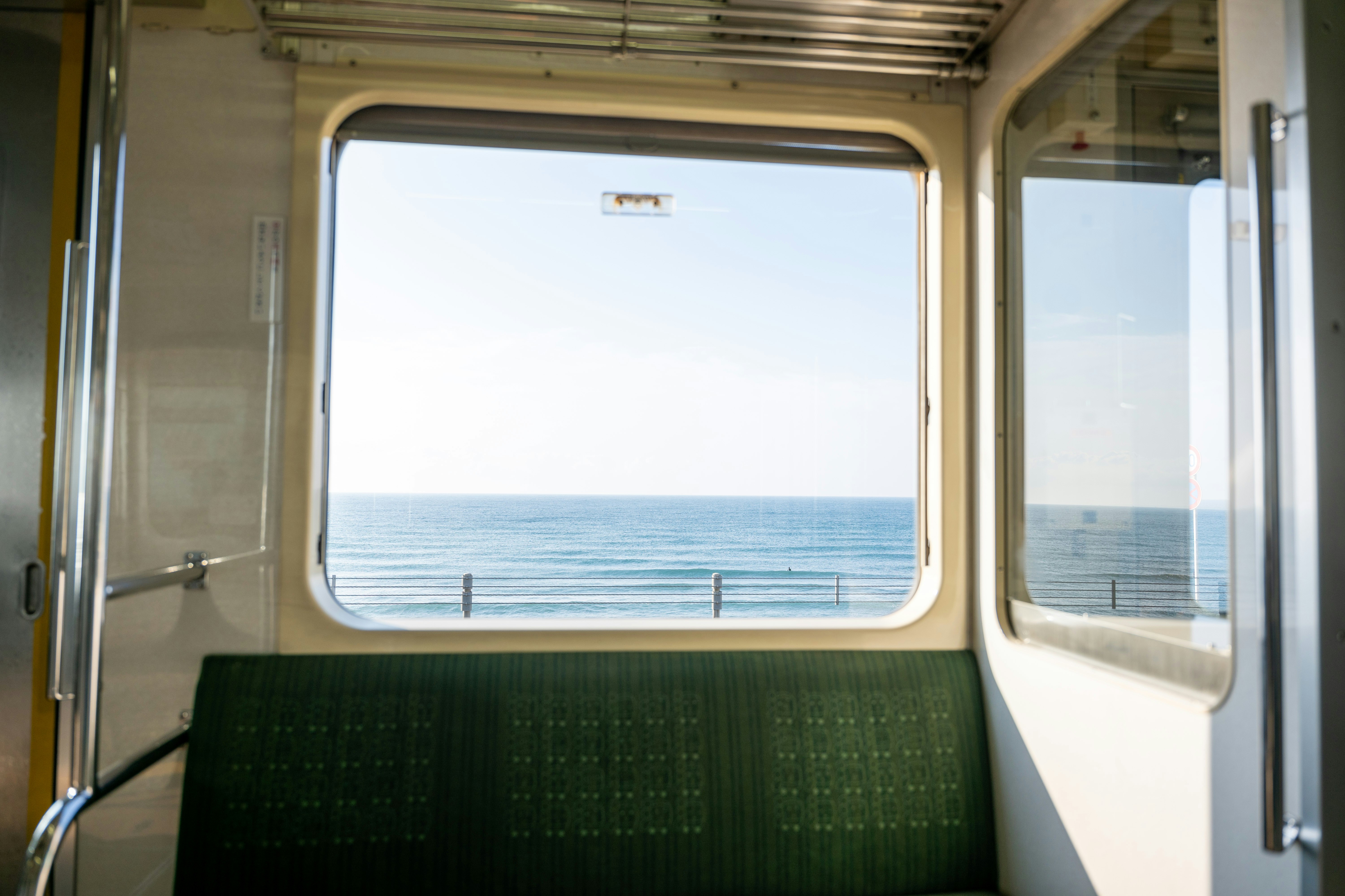 海を見渡す電車の車両内の窓からの景色